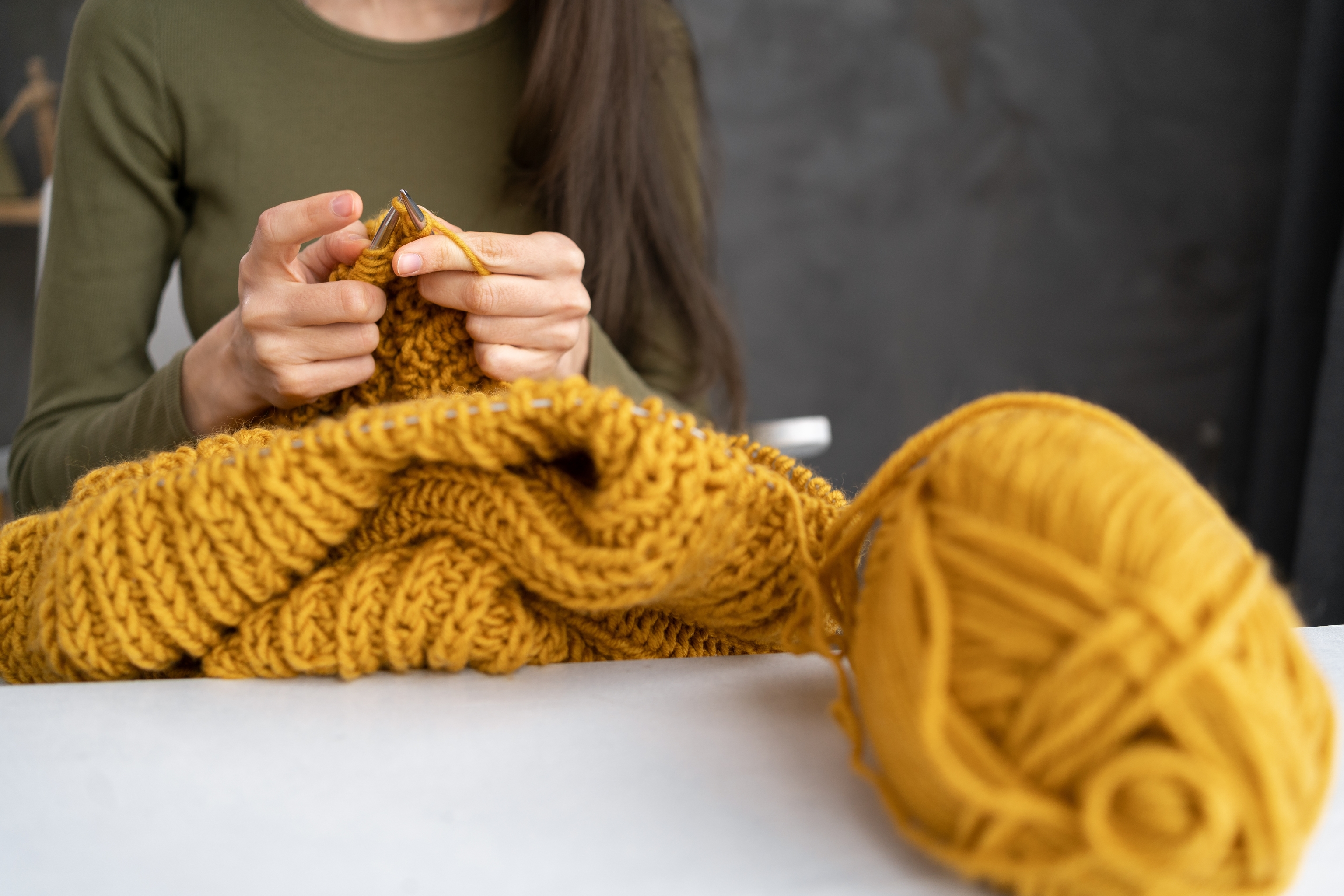 A woman knits a sweater.