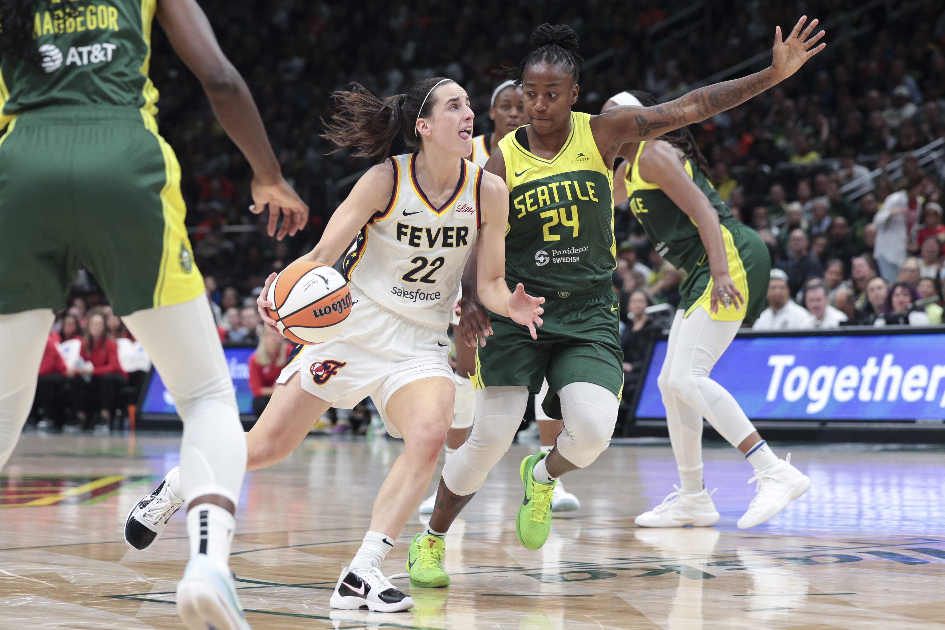 Caitlin Clark drives as Seattle Storm guard Jewell Loyd.