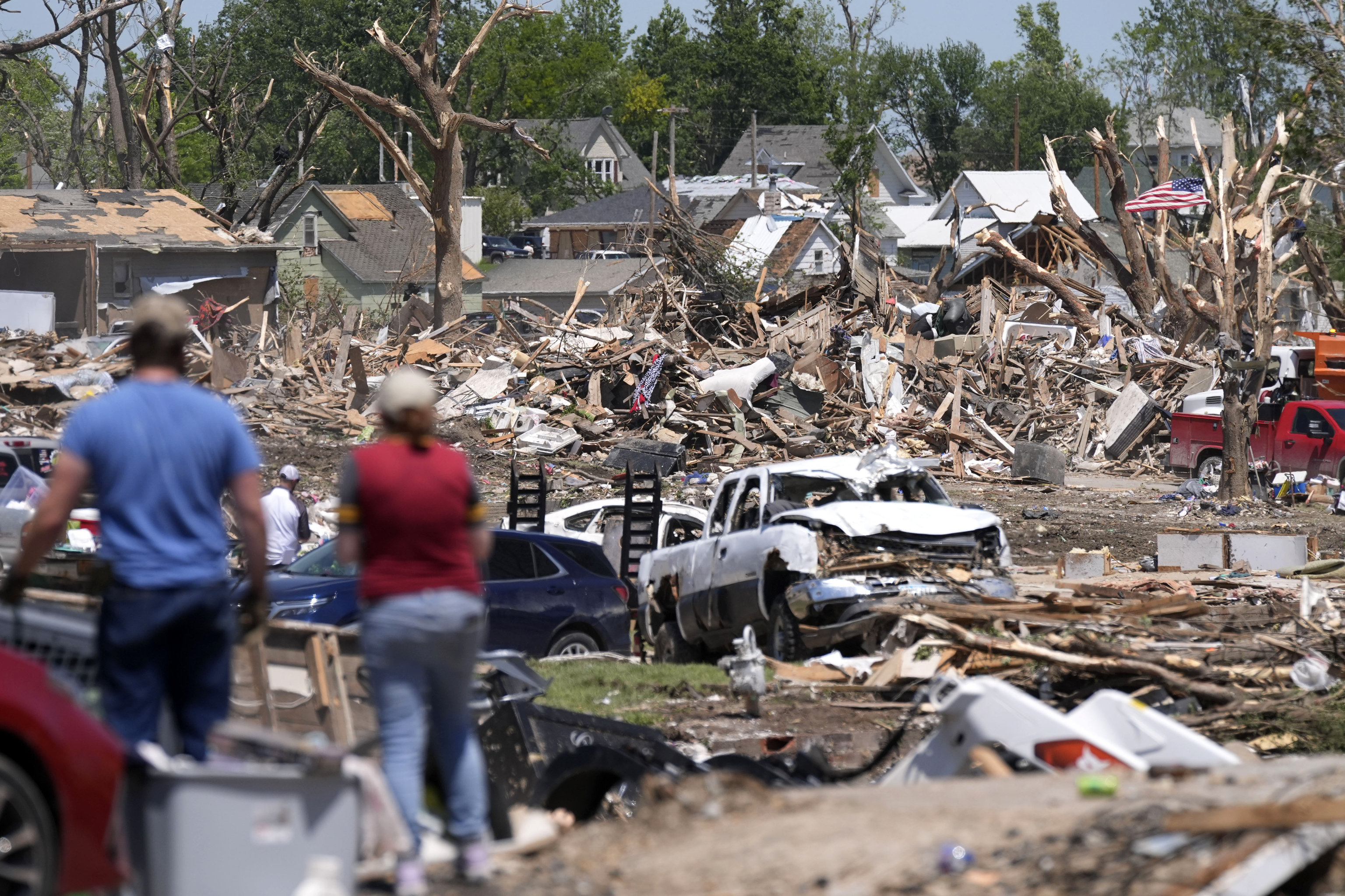 People survey a tornado damaged neighborhood.