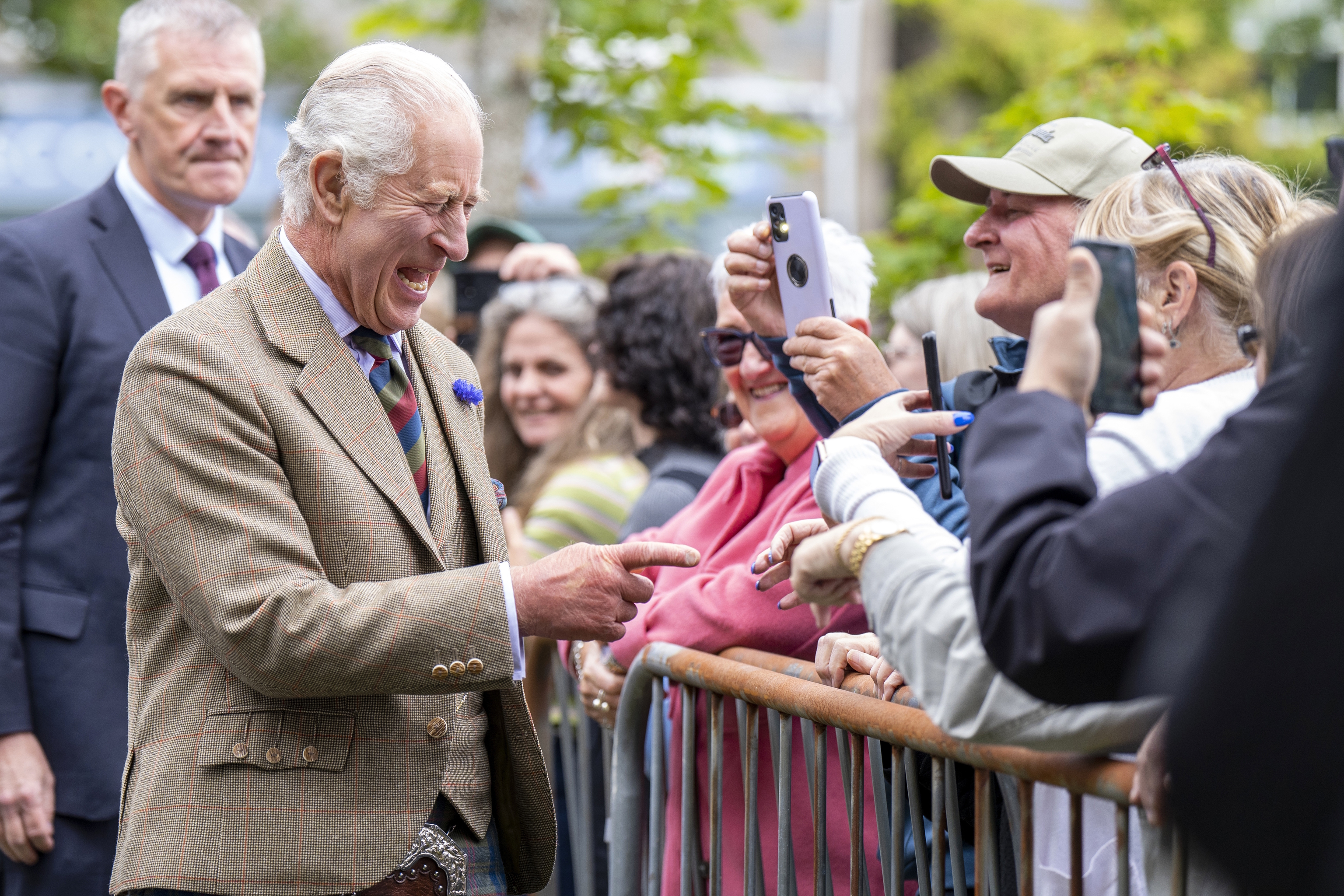 King Charles III greets a group of people.