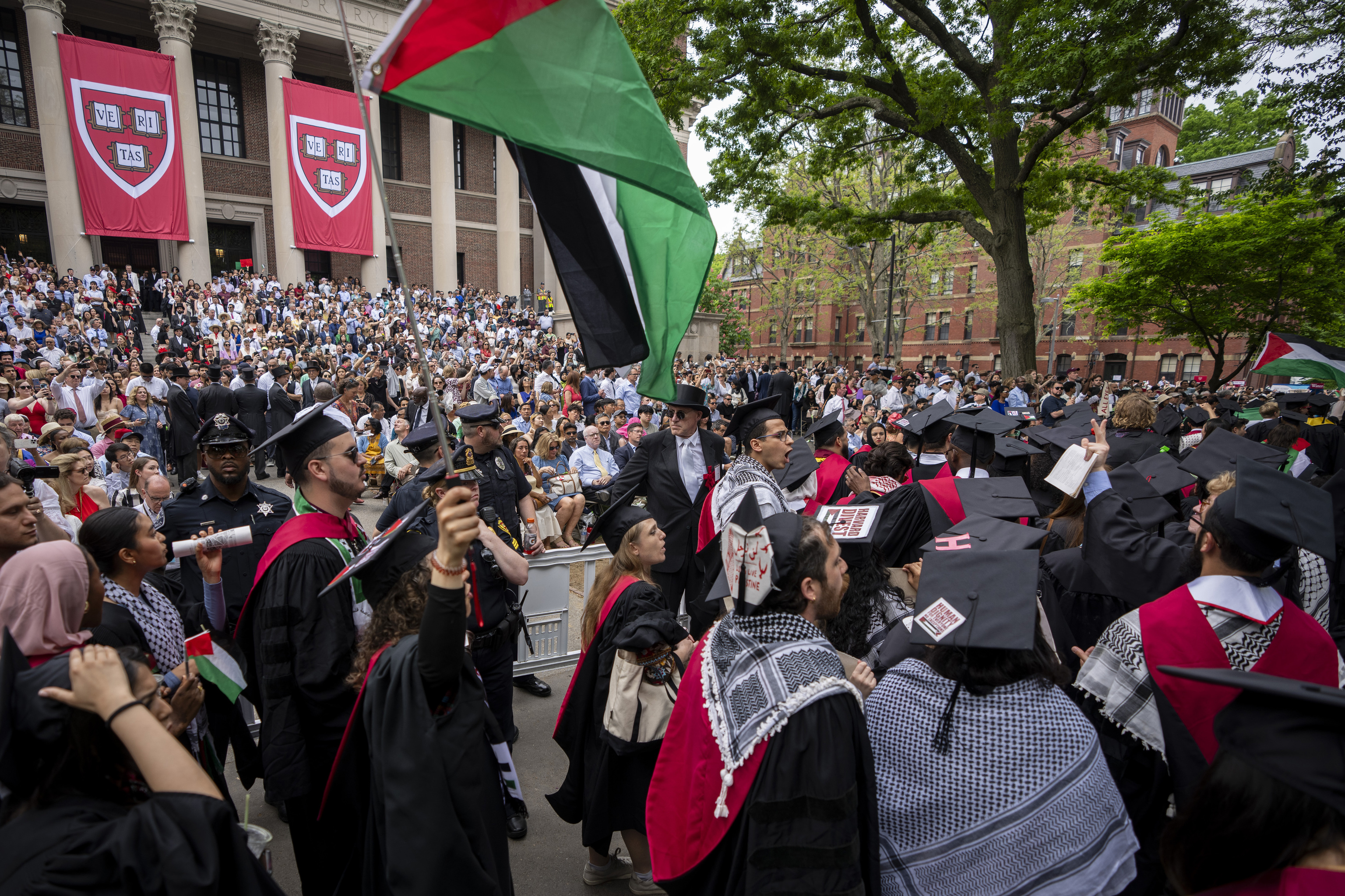 Graduating students hold Palestinian flags and chant as they walk outould not be able to receive diplomas alongside their classmates.