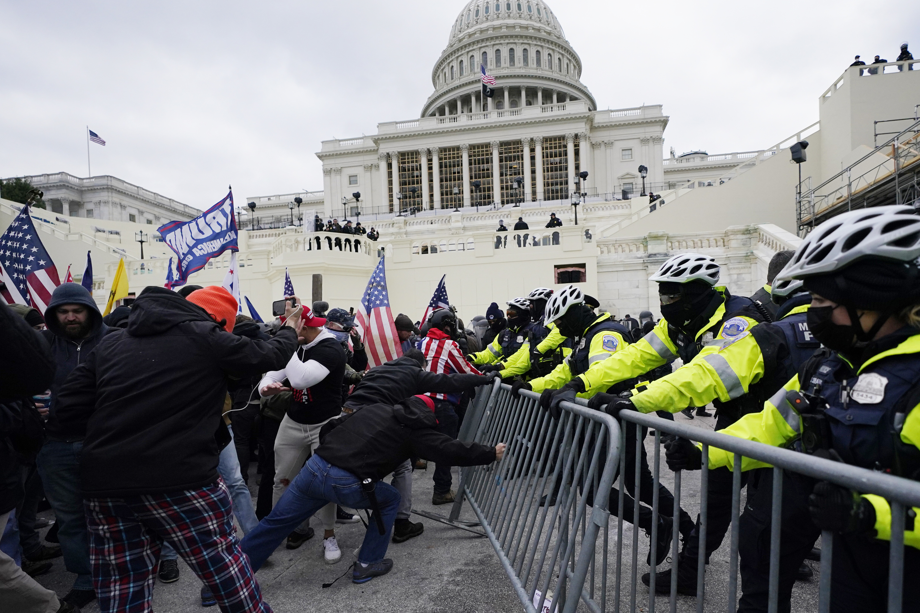 Insurrectionists loyal to President Donald Trump try to break through a police barrier.