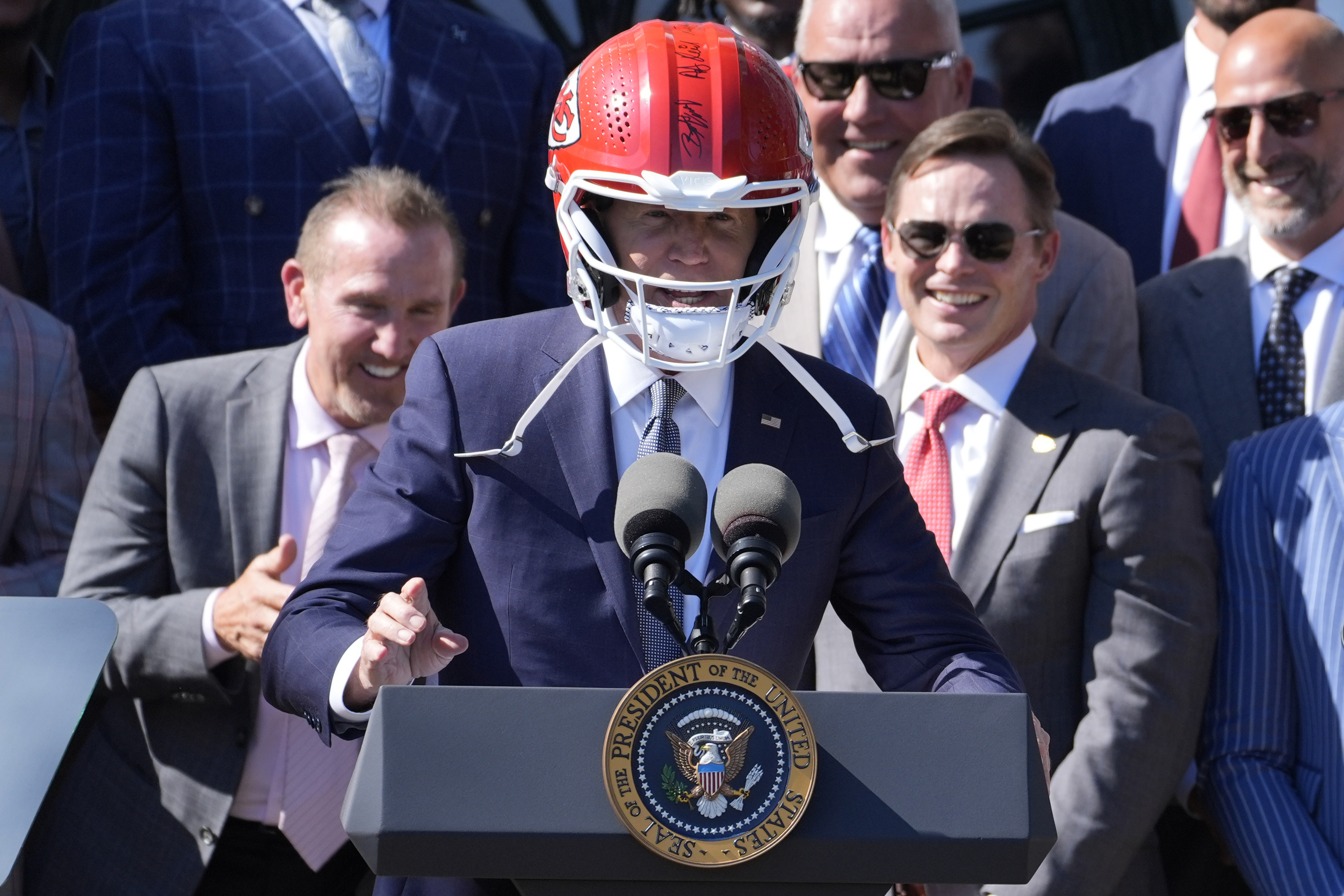 President Joe Biden wears a Chiefs helmet.