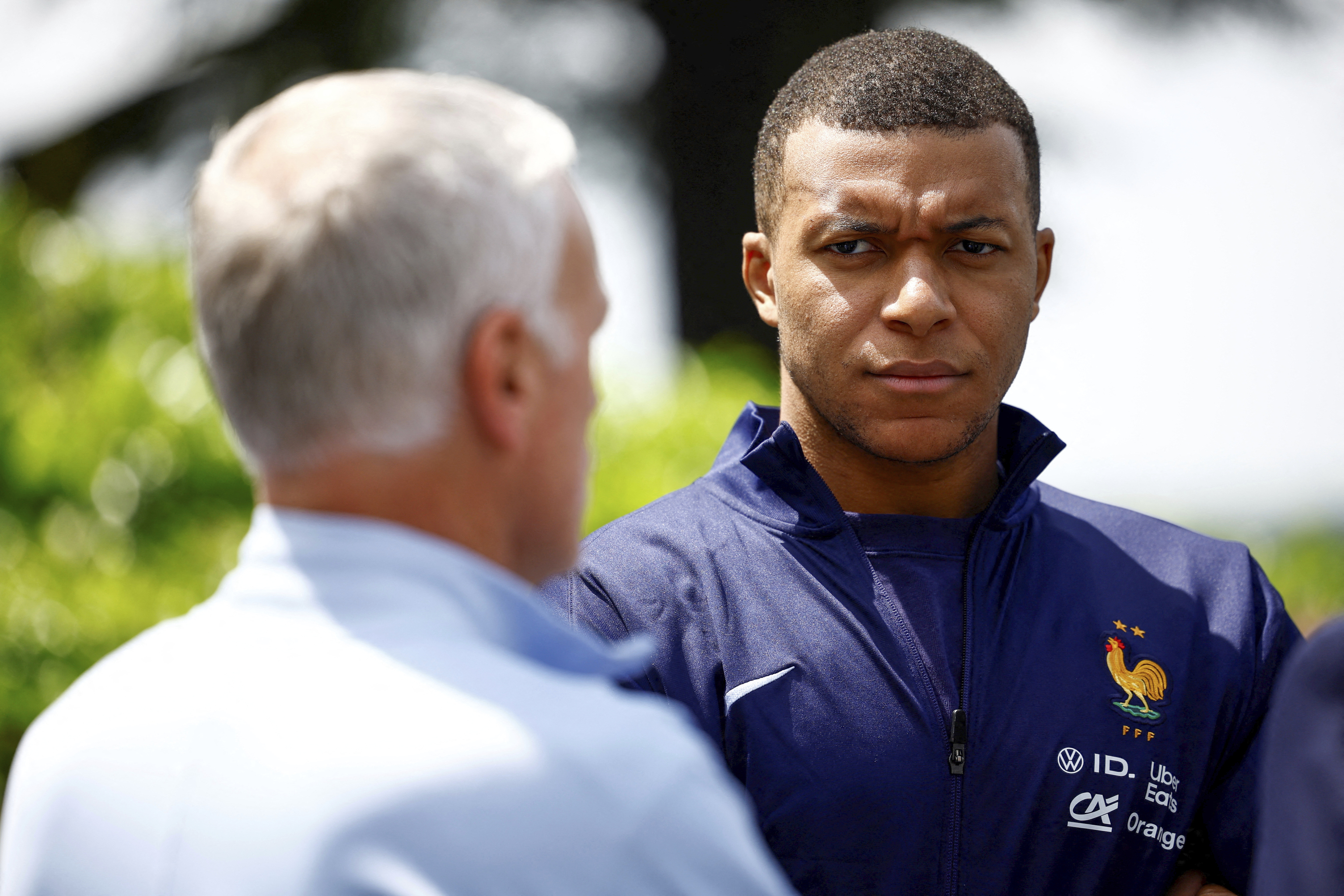 French soccer player Kylian Mbappe, right, listening to head coach Didier Deschamps.