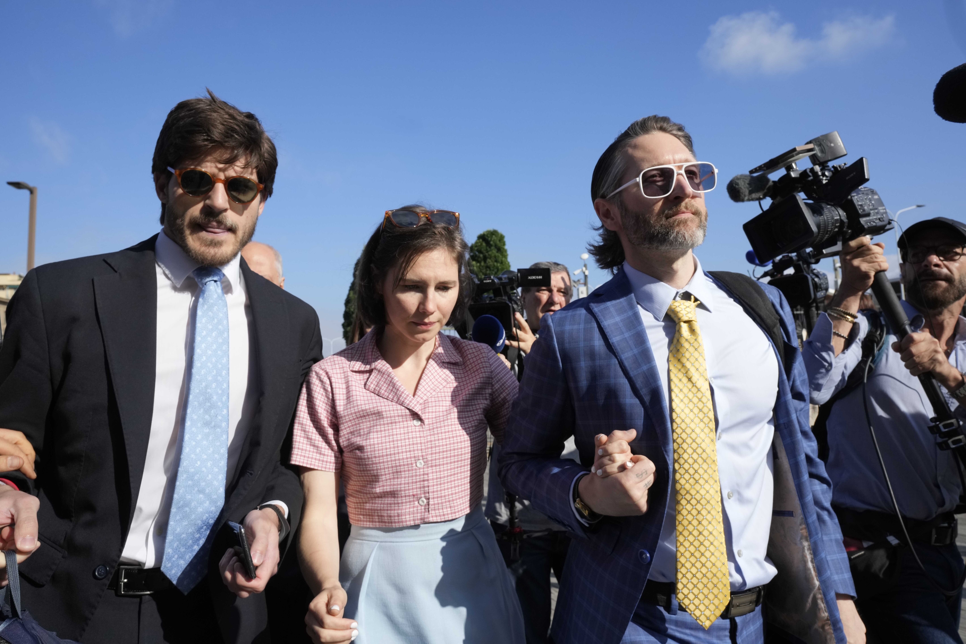 Amanda Knox arrives flanked by her husband (r) and her lawyer.