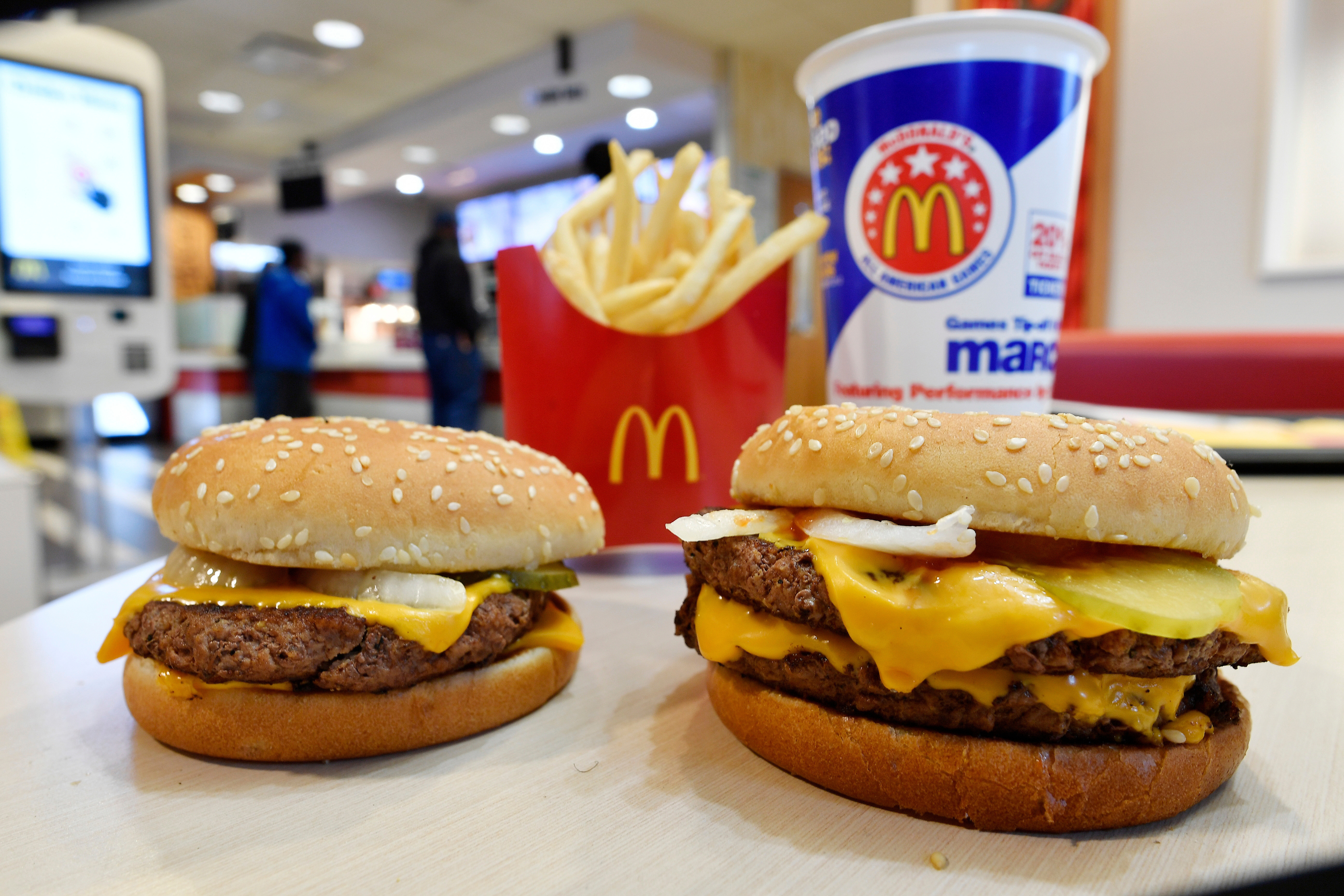 A McDonald's Quarter Pounder, left, and Double Quarter Pound burger is shown with fresh beef in Atlanta