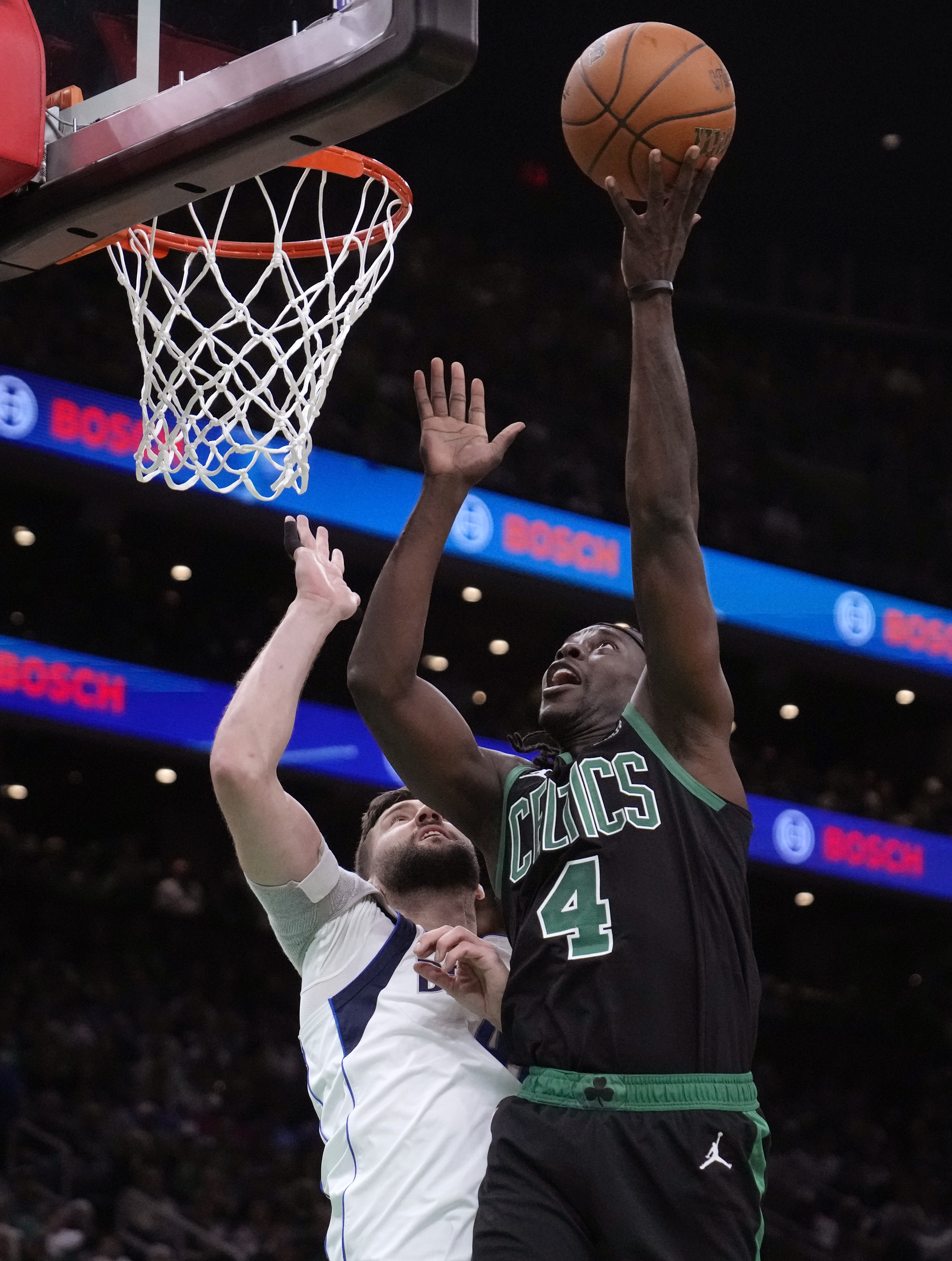 Boston Celtics guard Jrue Holiday shoots over Dallas Mavericks forward Maxi Kleber (42).