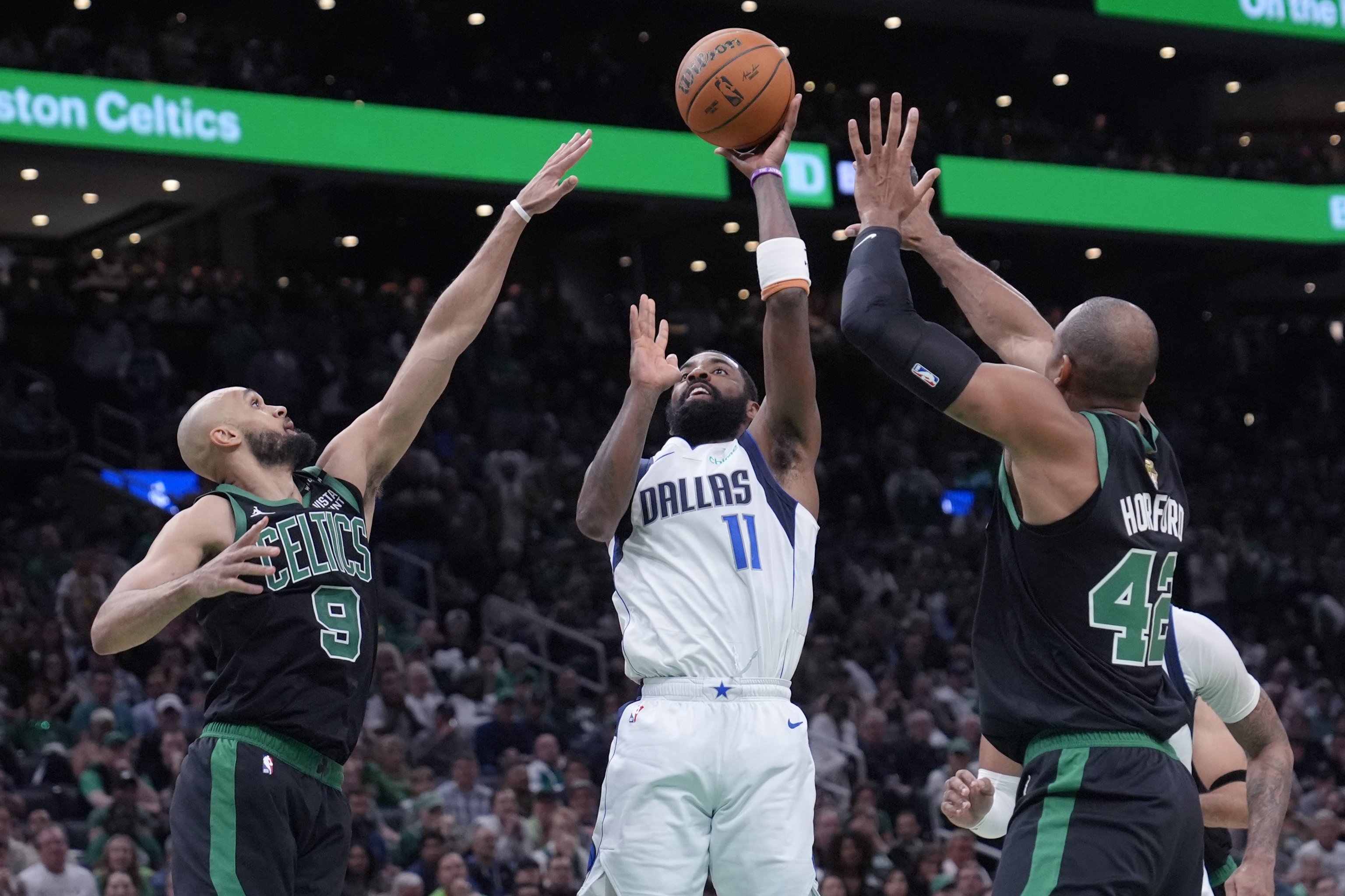 Dallas Mavericks guard Kyrie Irving (11) shoots while defended.