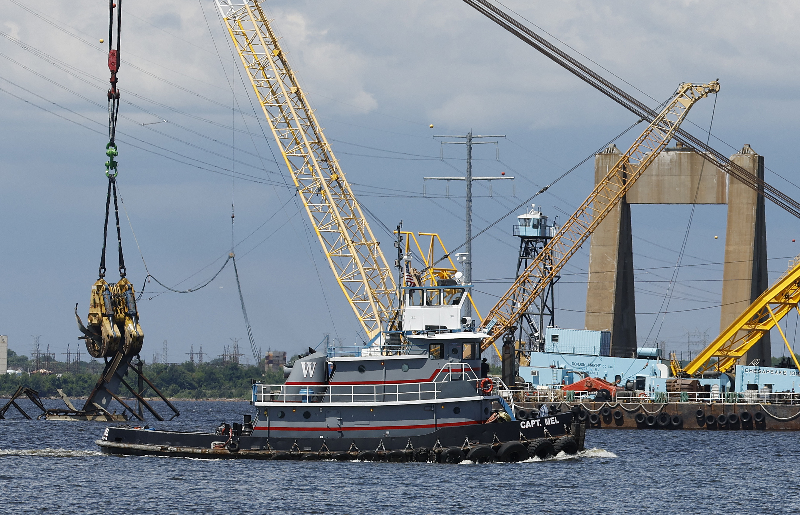 A tug boat passes by Francis Scott Key Bridge.