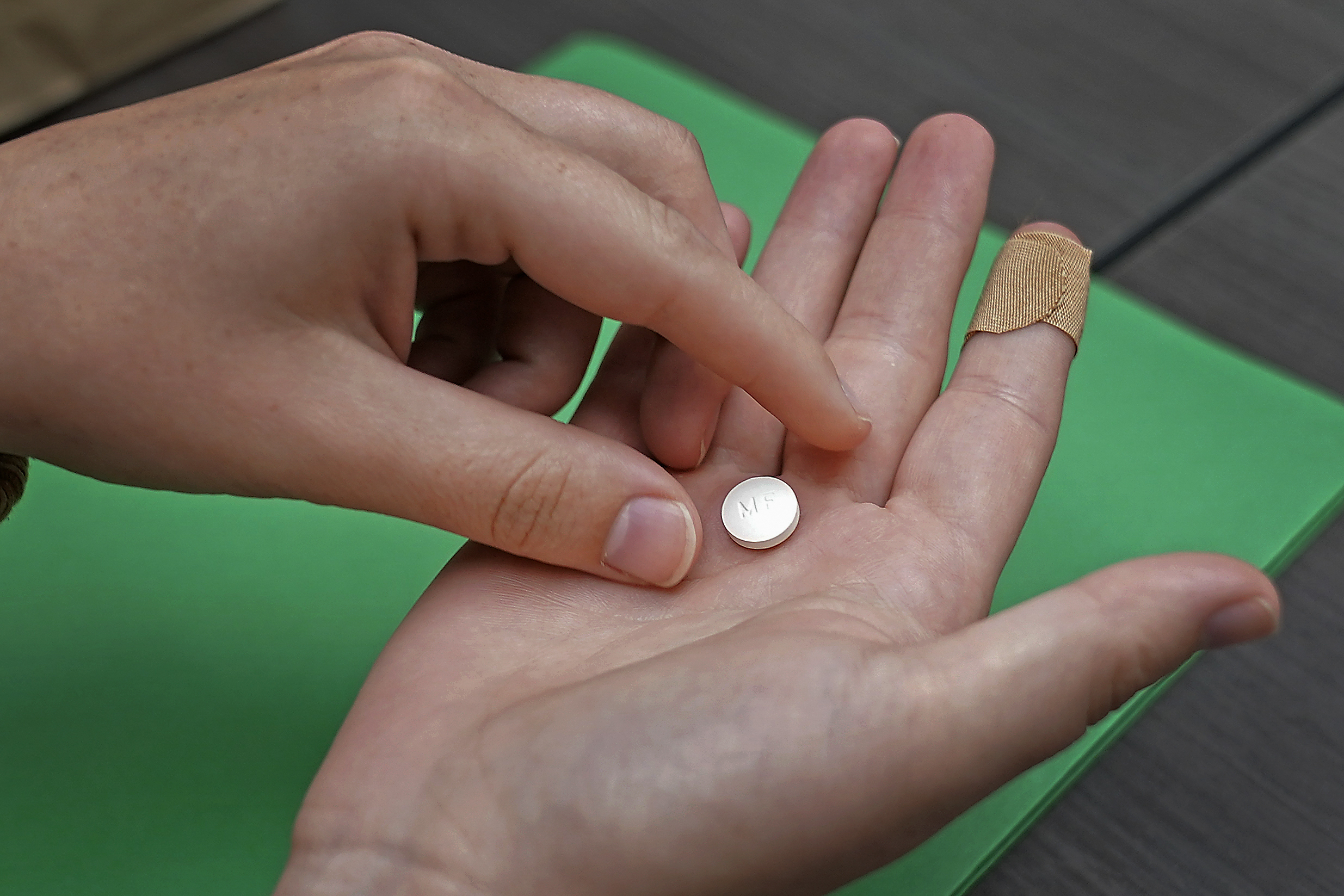 A patient prepares to take the first of two combination pills, mifepristone, for a medication abortion.