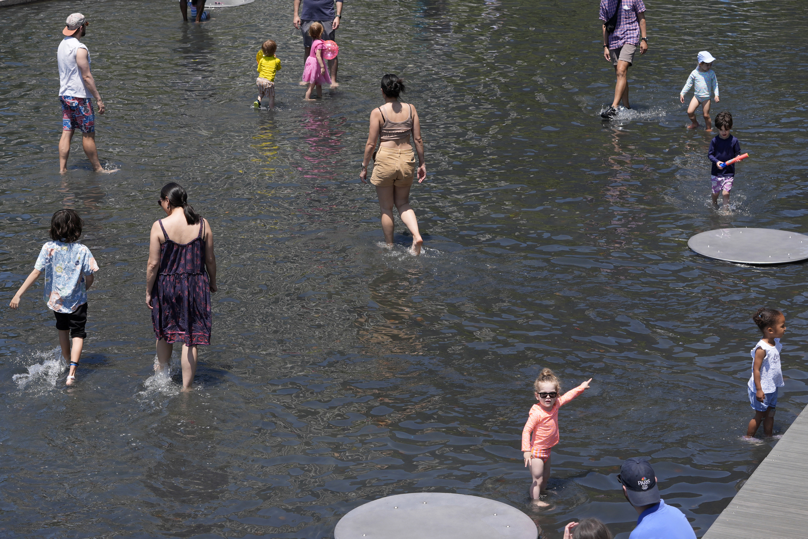 Families wade in ankle deep water at Yards Park Canal Basin.