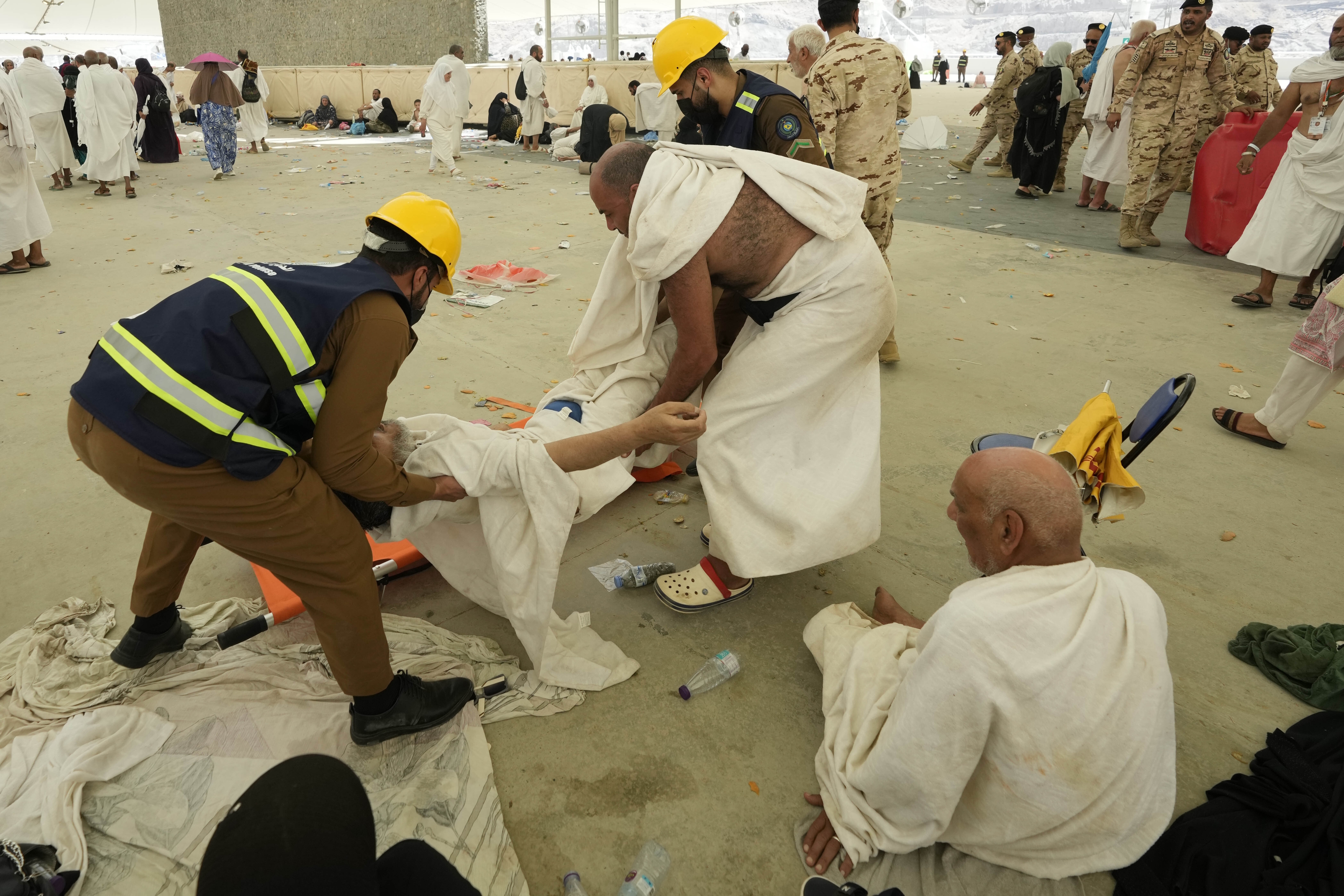 Paramedics carry a muslim pilgrim for a medical check.