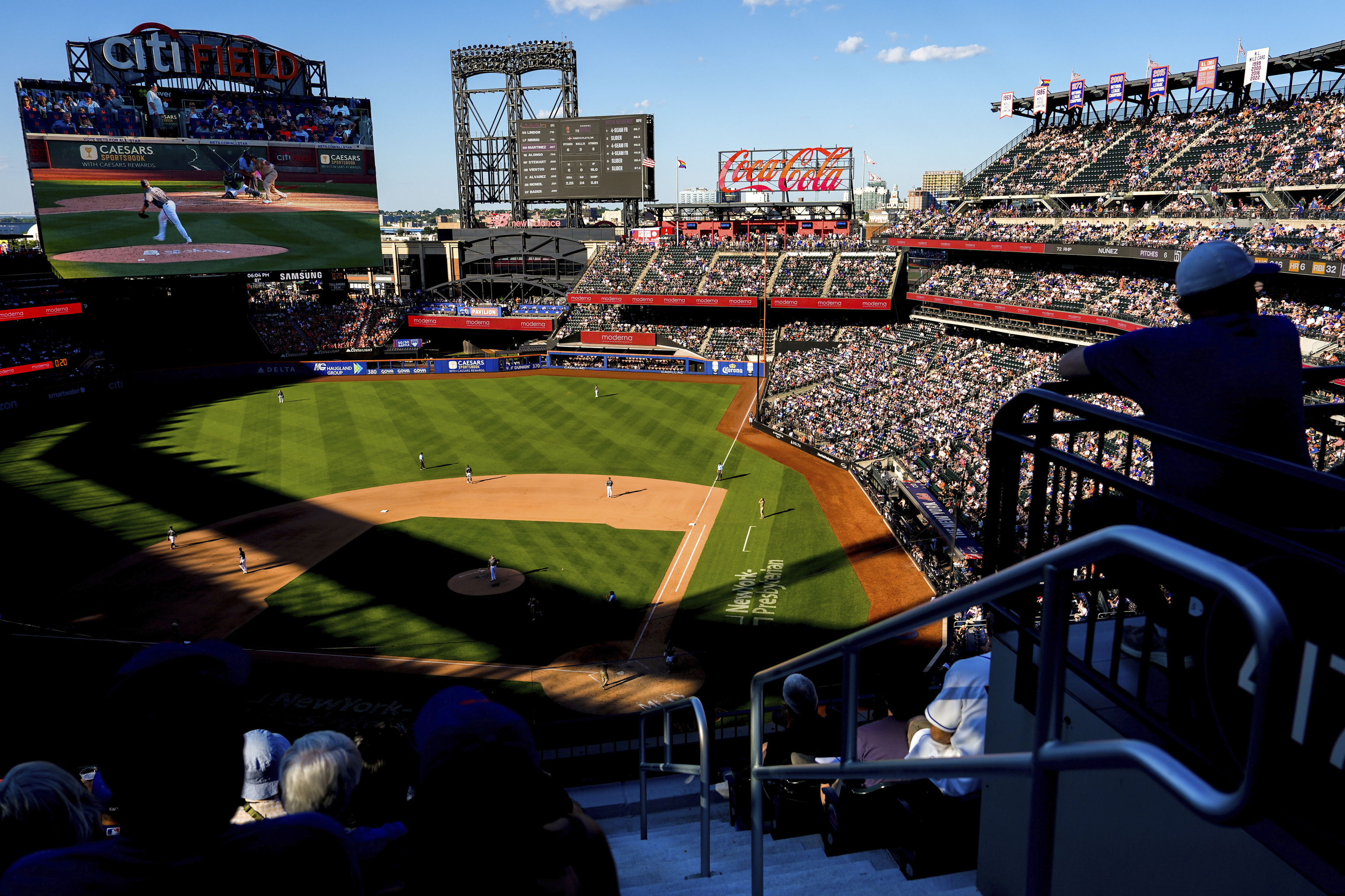 Fans watch the New York Mets and the San Diego Padres play during the seventh inning of a baseball game.