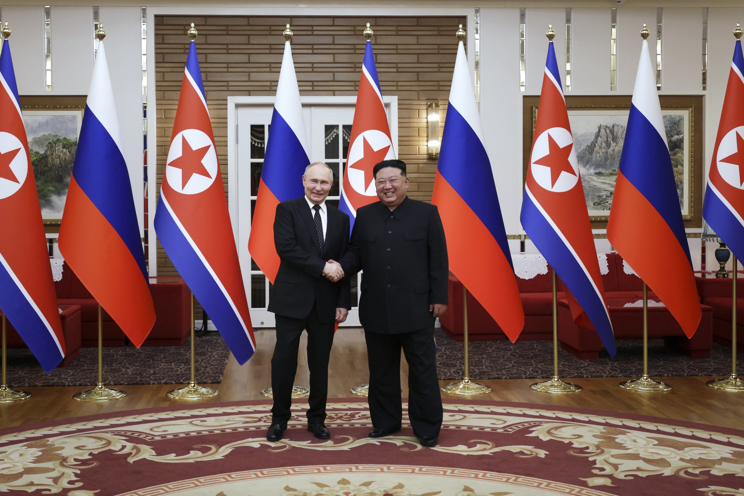 Vladimir Putin and Kim Jong Un pose.