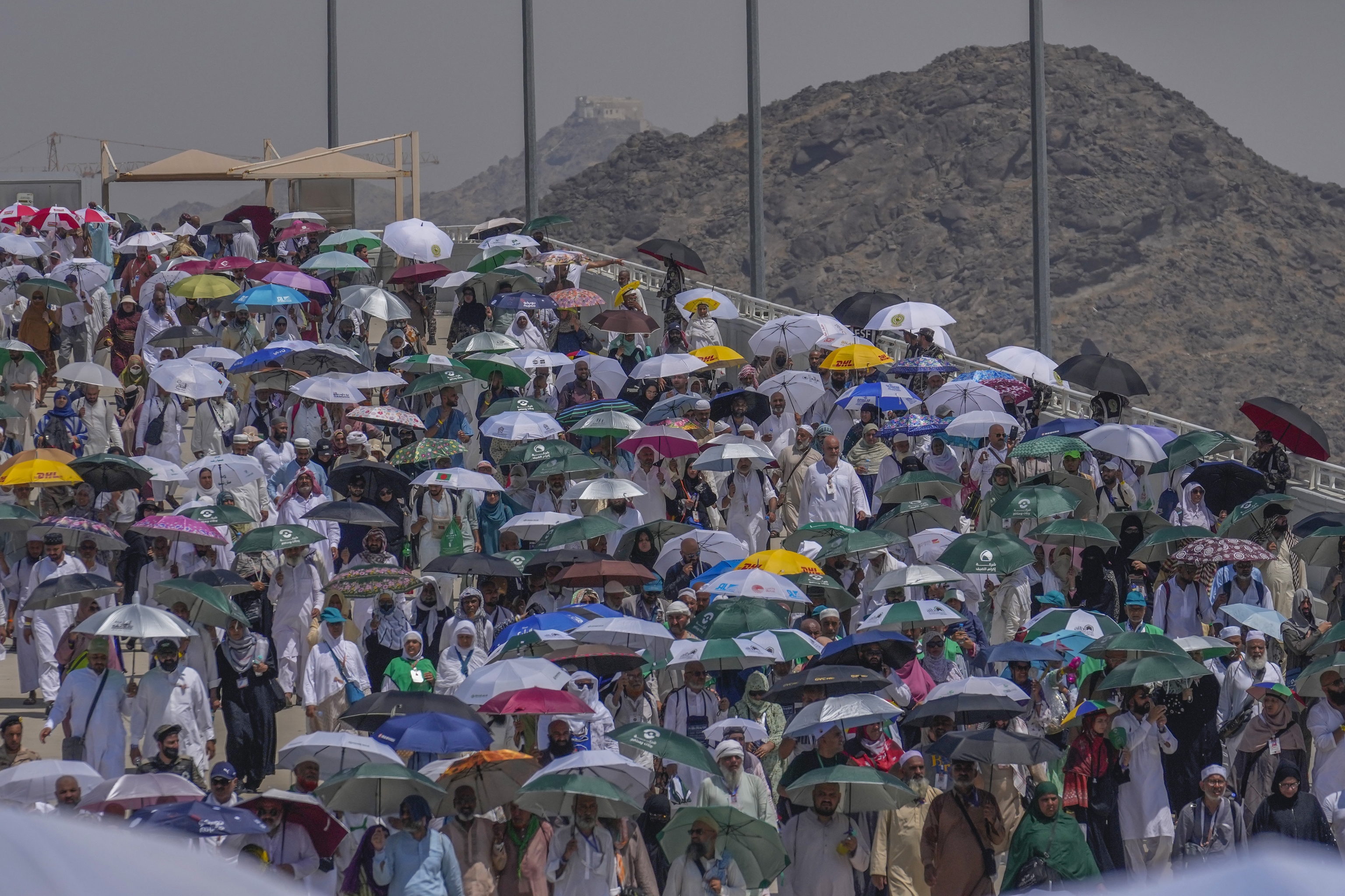 Muslim pilgrims use umbrellas to shield from the sun.