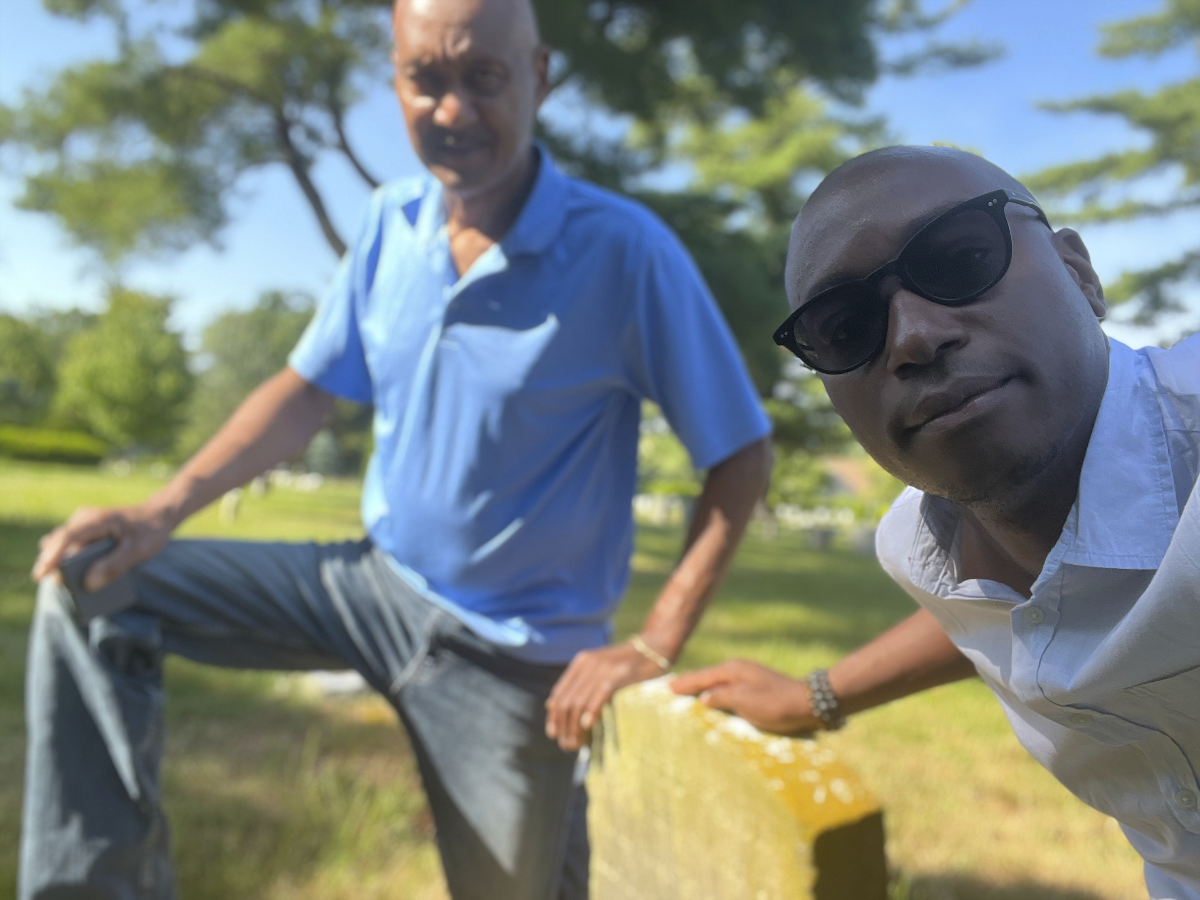 The Associated Press religion reporter Darren Sands and his father, Lonnie Sands, pose by the gravestone of his great-great-great-great-grandfather and Civil War soldier Hewlett Sands in Westbury, N.Y.