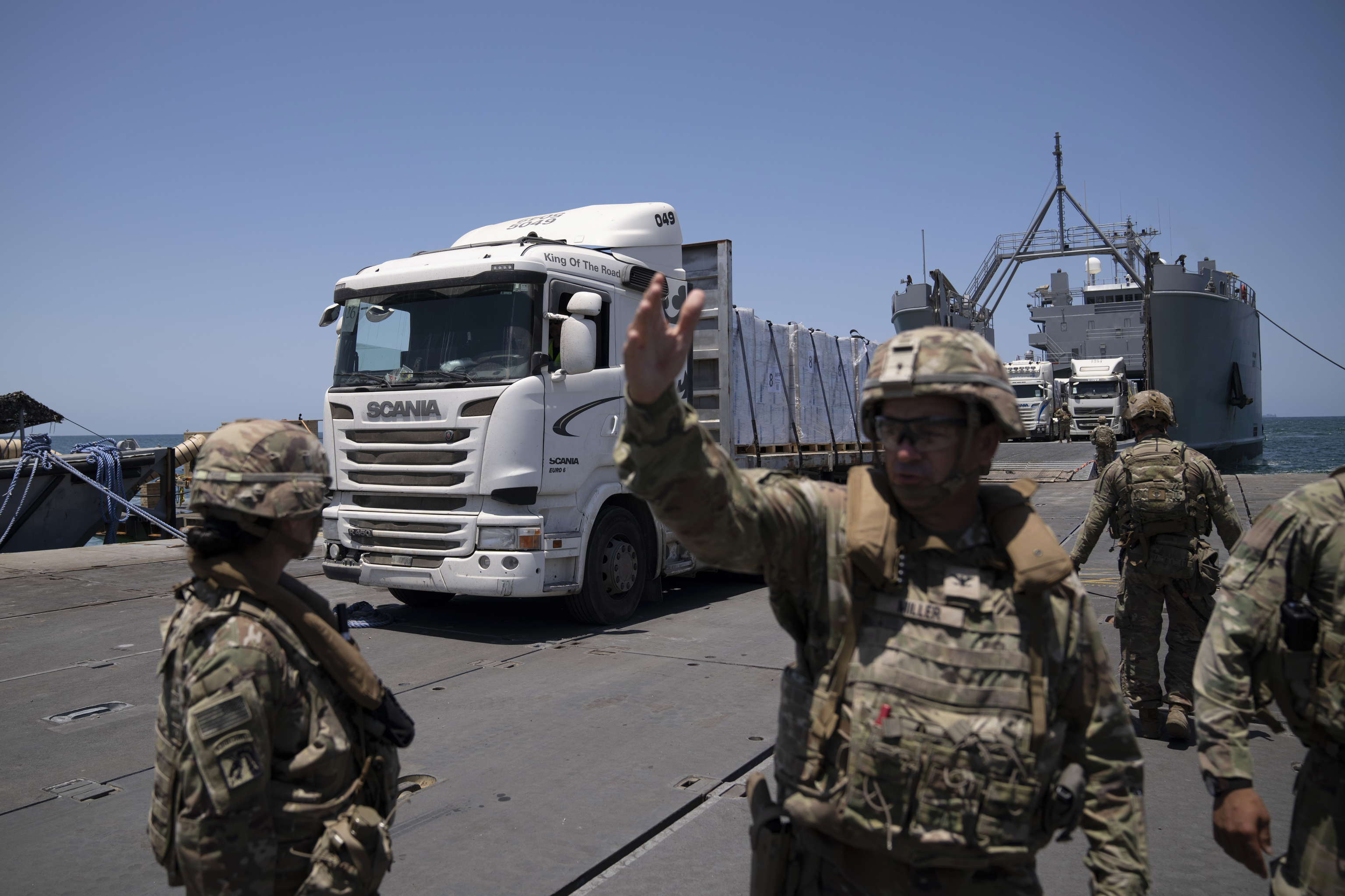 A U.S. Army soldier gestures as trucks loaded with humanitarian aid arrives.