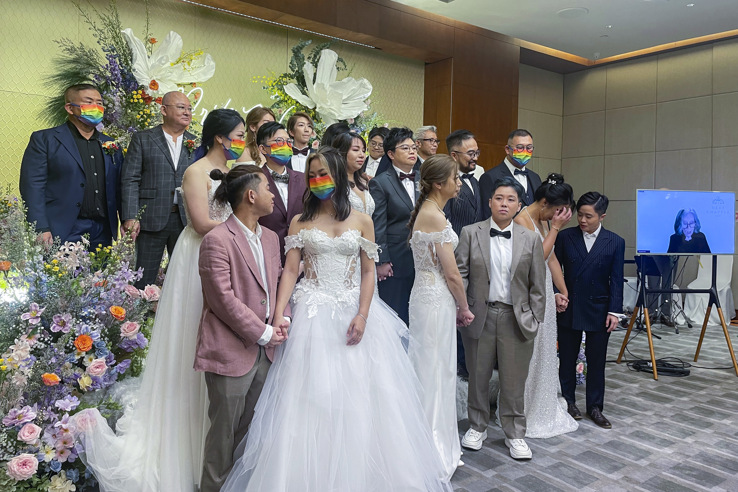 Ten same-sex couples who got married in the United States over the internet stand during their wedding at Eaton Hotel,