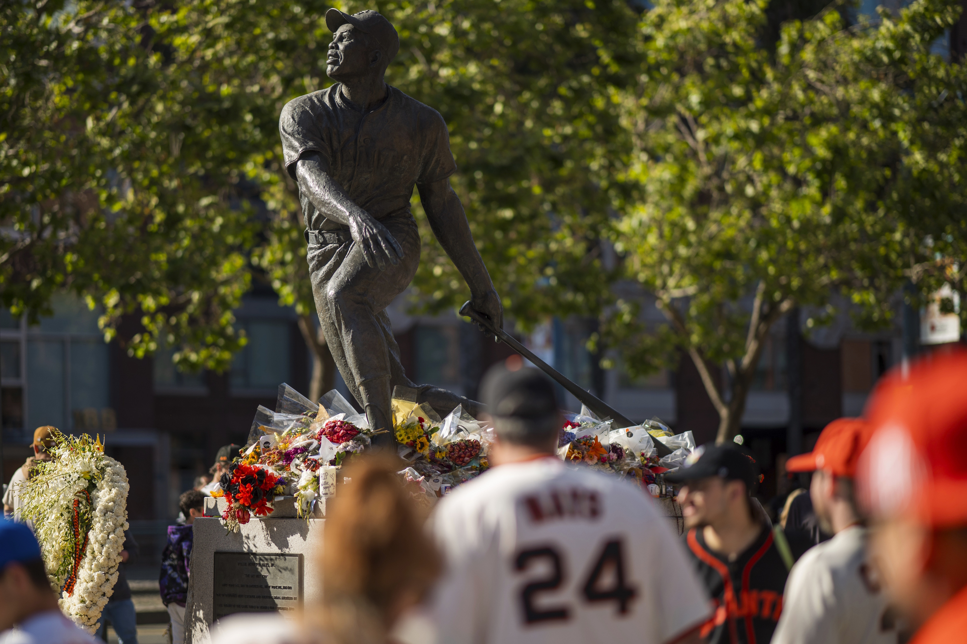 Fans walk by a tribute for the late Willie Mays.