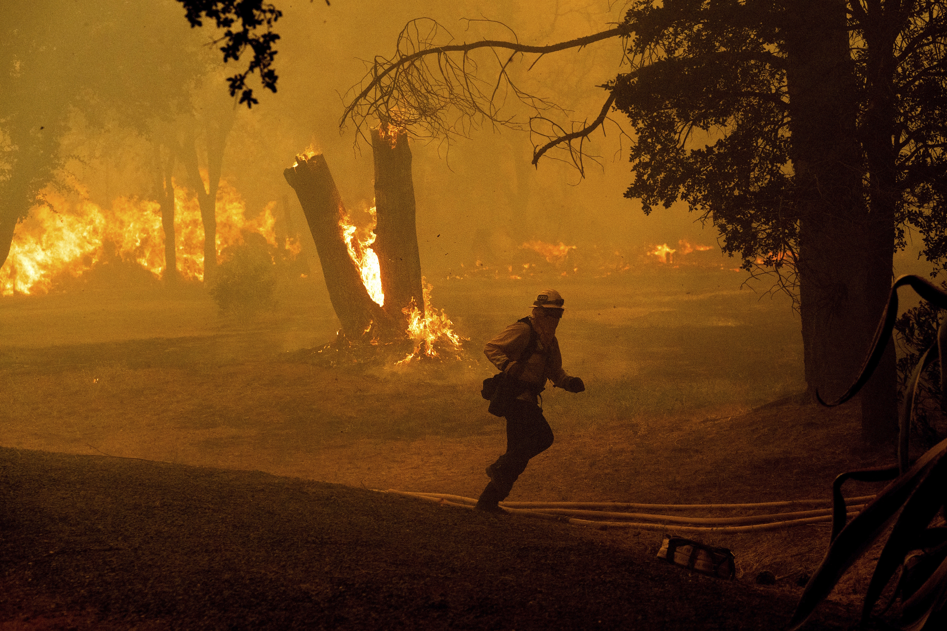 A firefighter runs while battling the Thompson Fire burning.