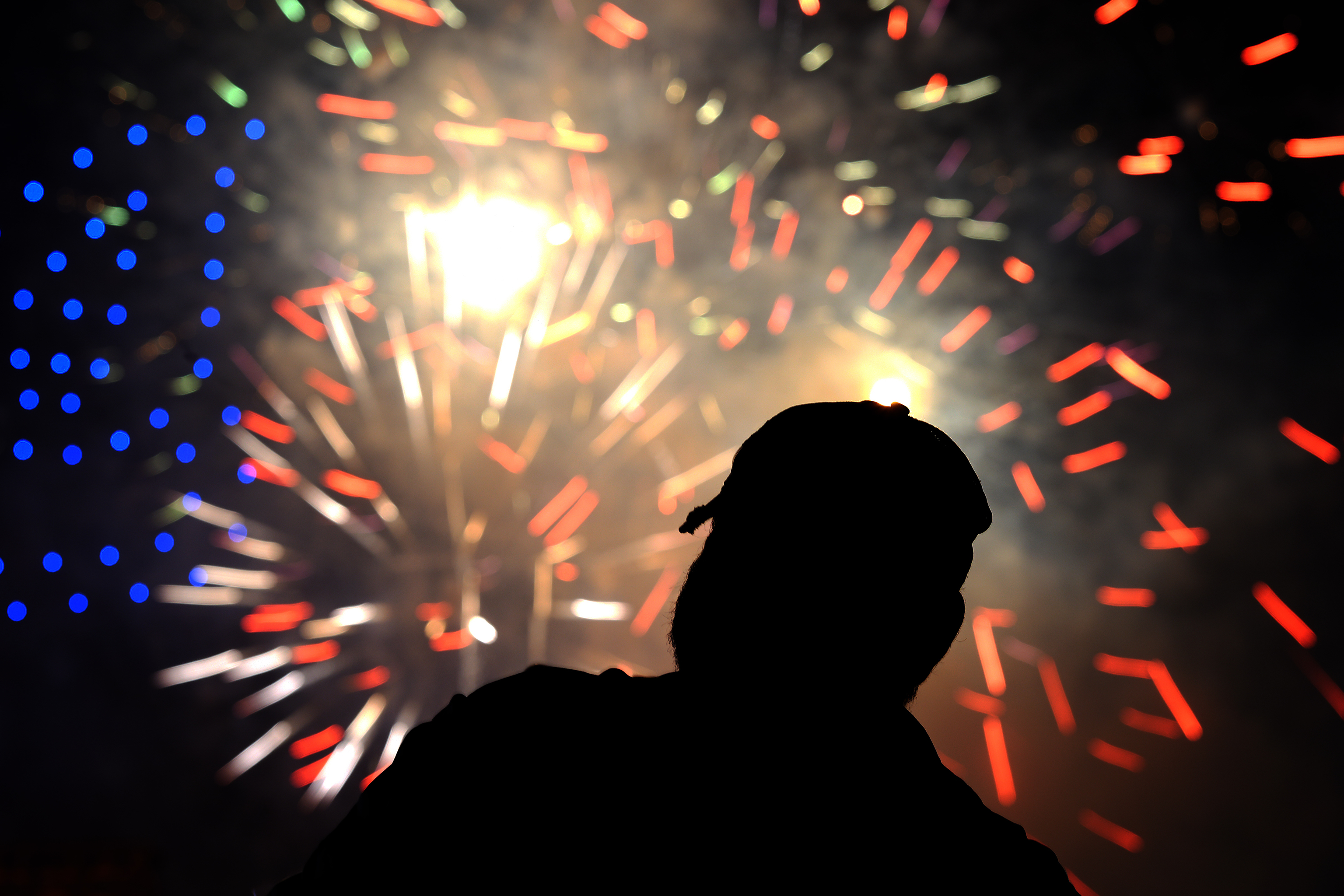 A fan watches a Fourth of July fireworks display