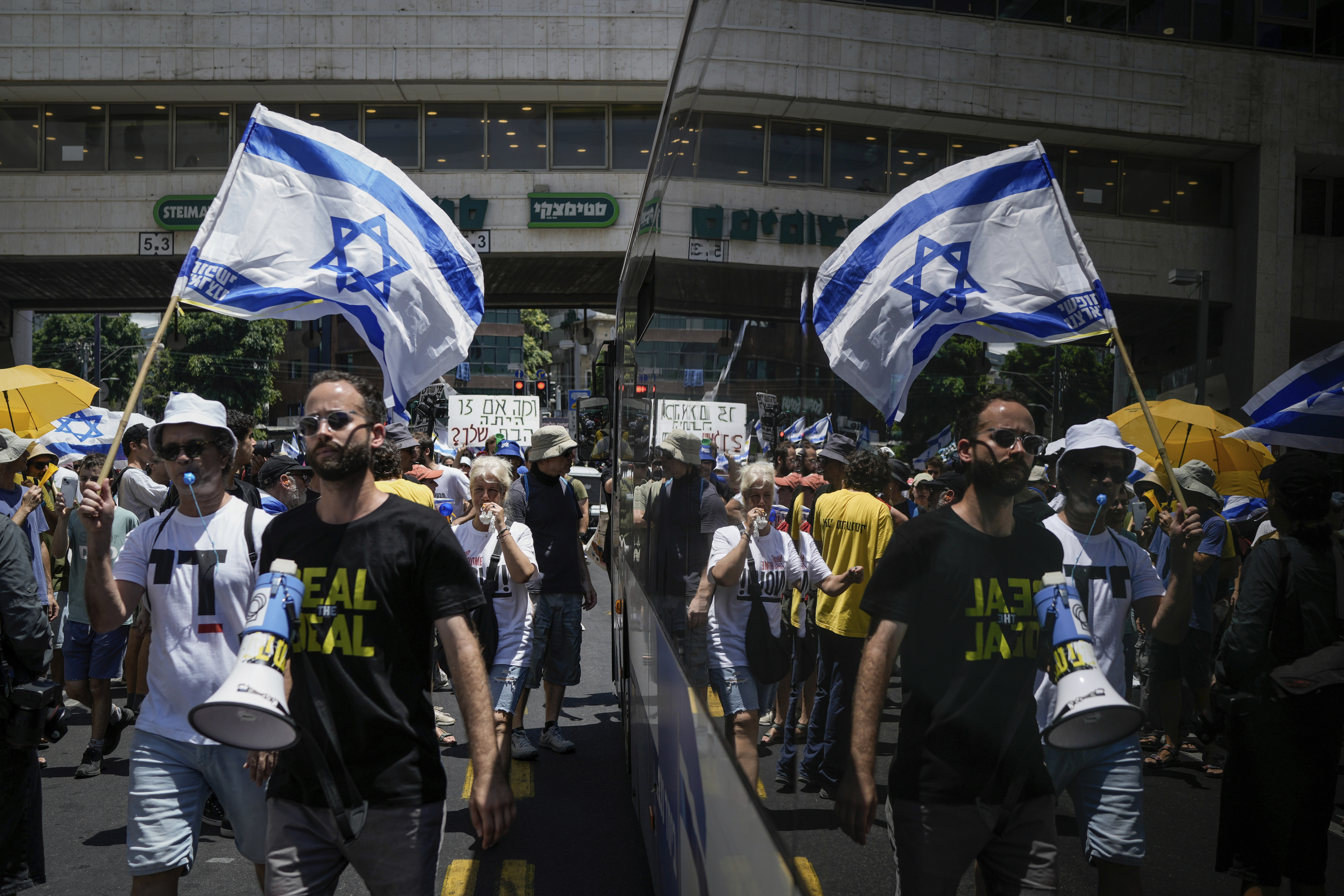 Demonstrators march with Israeli flags during a protest marking nine months since the start of the war.