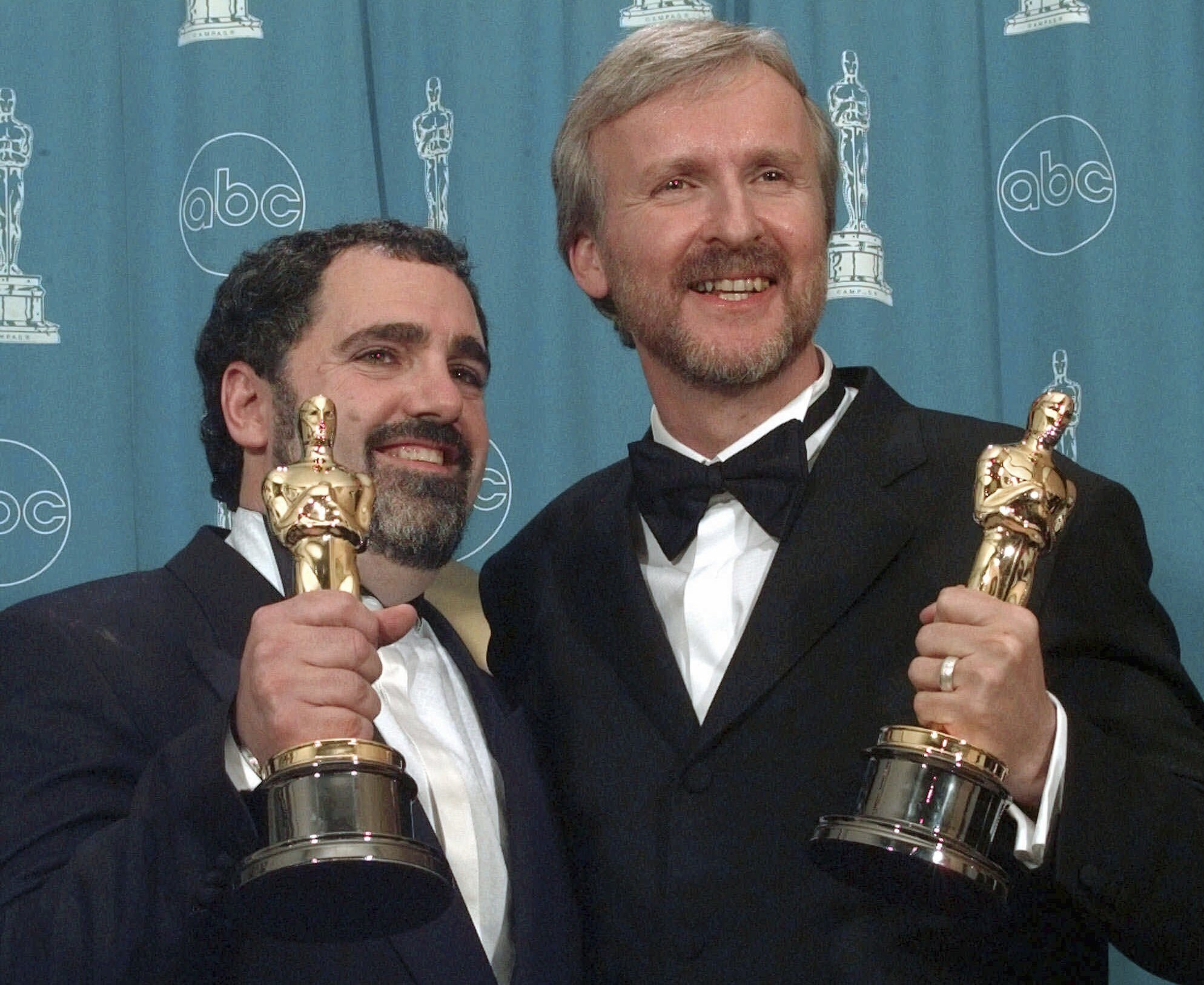 Cameron (r) and Jon Landau hold the Oscars for "Titanic".