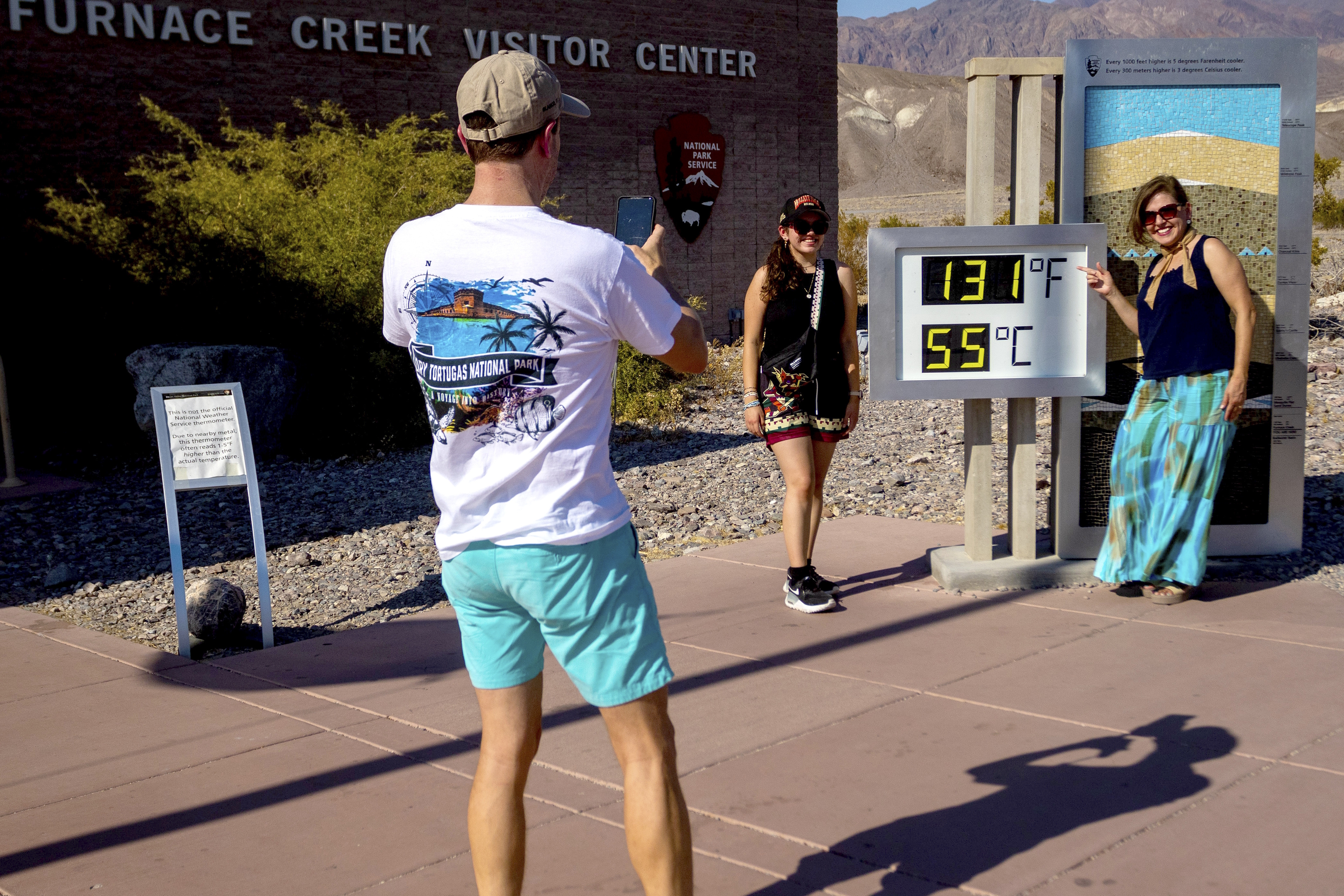 A family takes a photo by the thermometer in Death Valley.