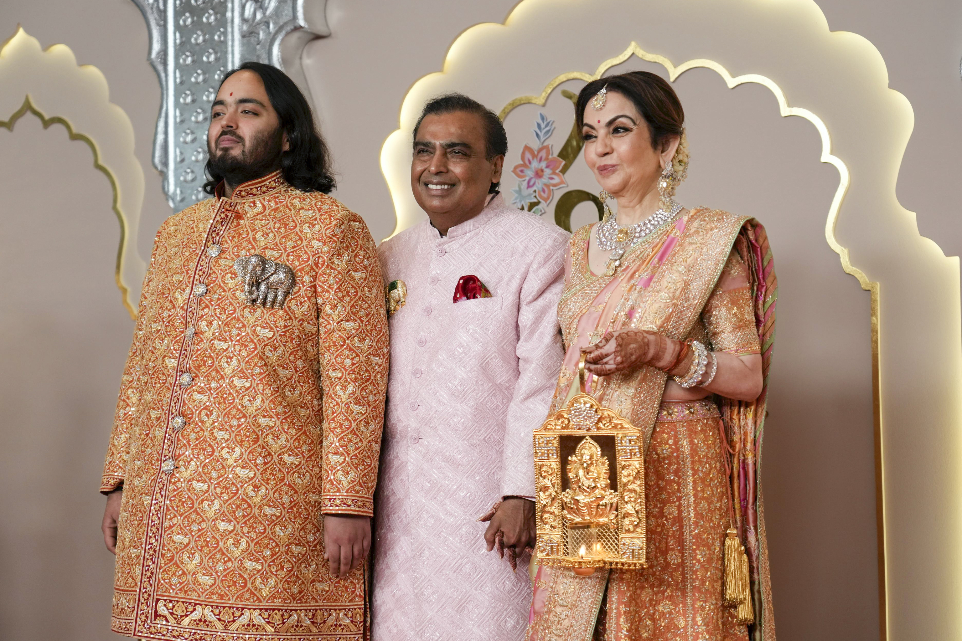 Billionaire Mukesh Ambani, center, poses with son Anant, and wife Nita.