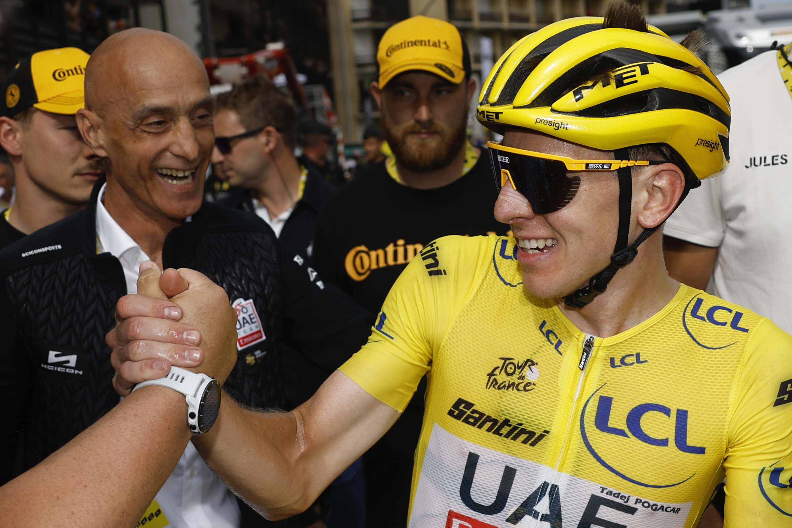 Tadej Pogacar, wearing the overall leader's yellow jersey, celebrates after crossing the finish line during the fourteenth stage of the Tour de France.