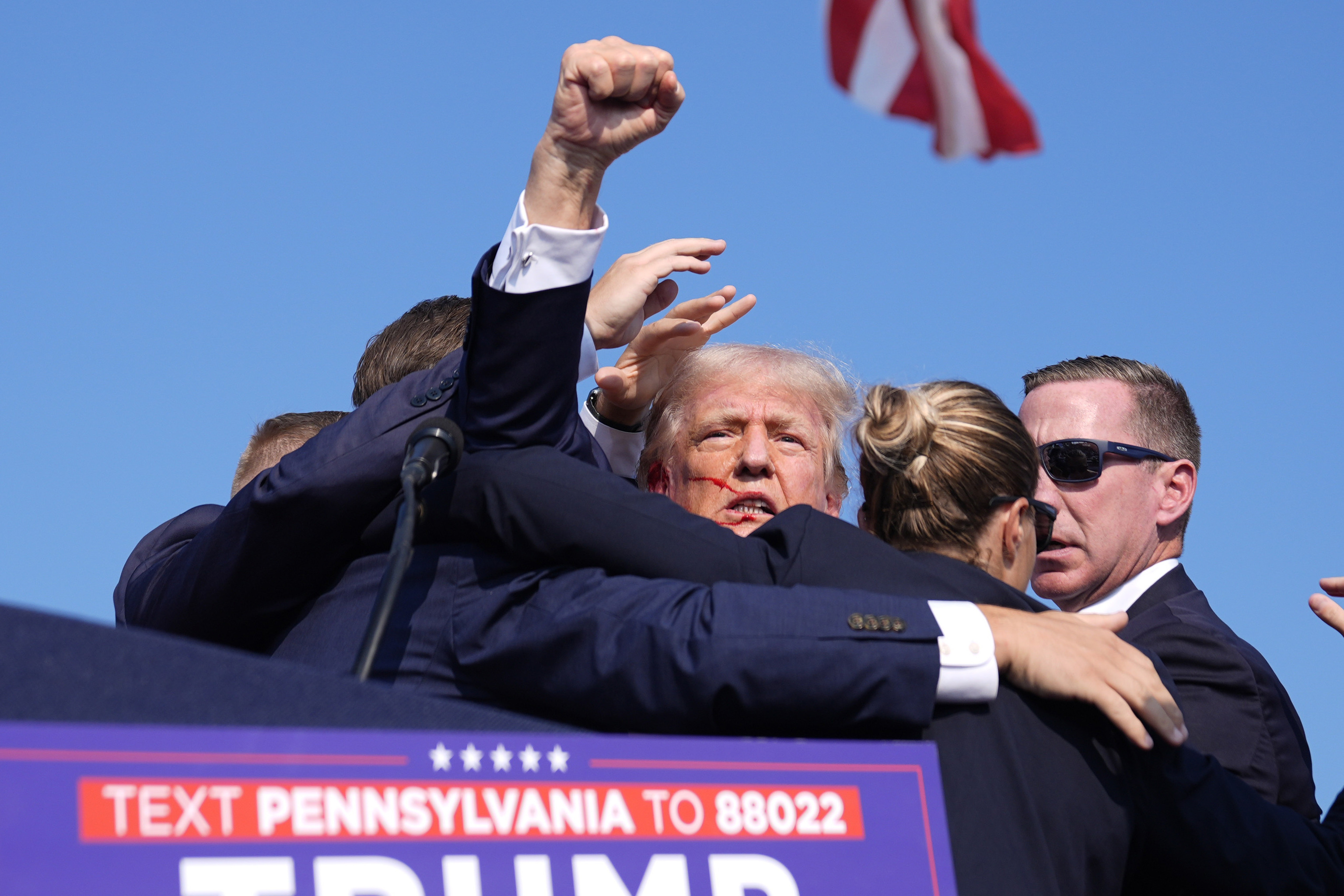 Republican presidential candidate former President Donald Trump gestures as he is surrounded by U.S. Secret Service agents.