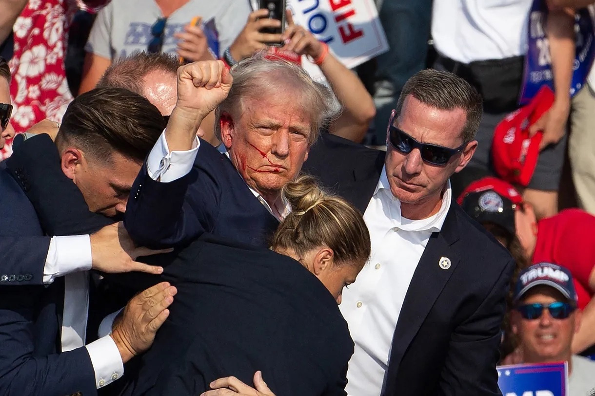 Trump, surrounded by Secret Service agents, after being shot.