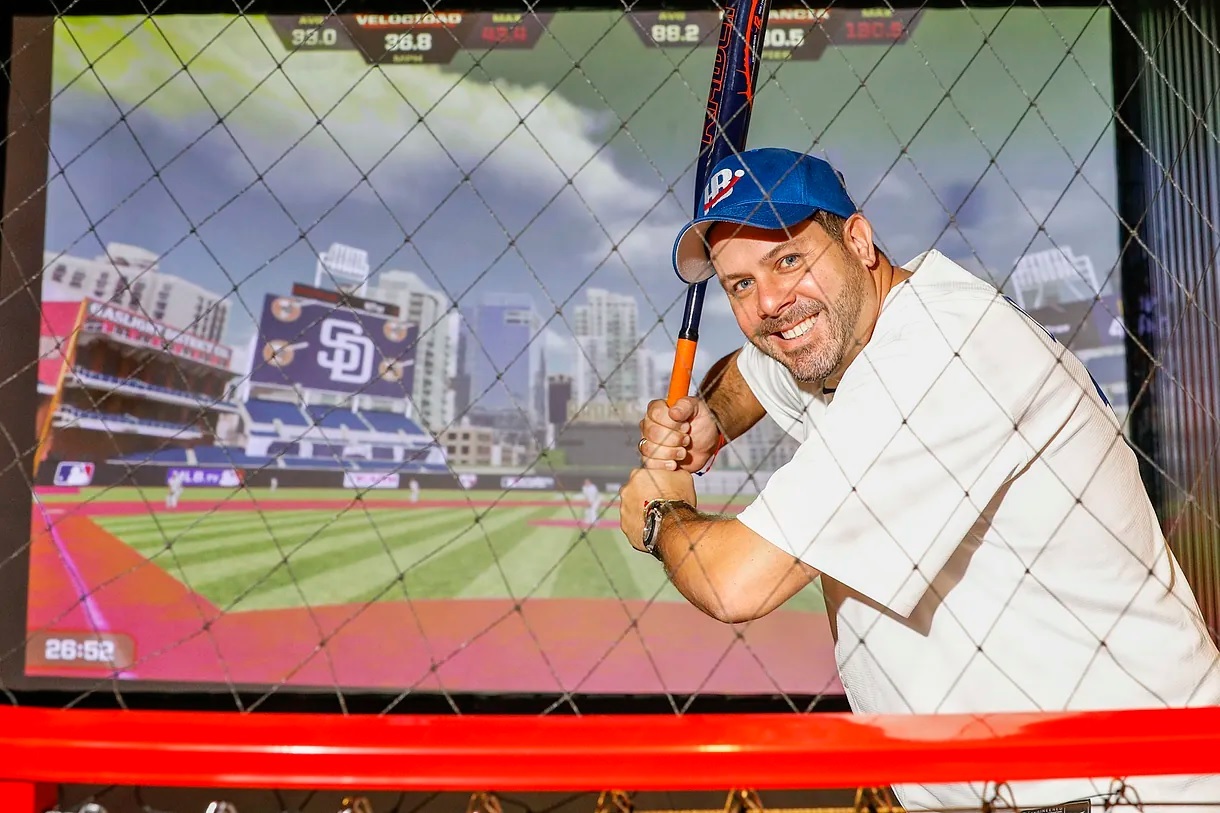 The restless businessman Fernando Rodrguez, a baseball enthusiast, poses at Hitball with a bat in hand.