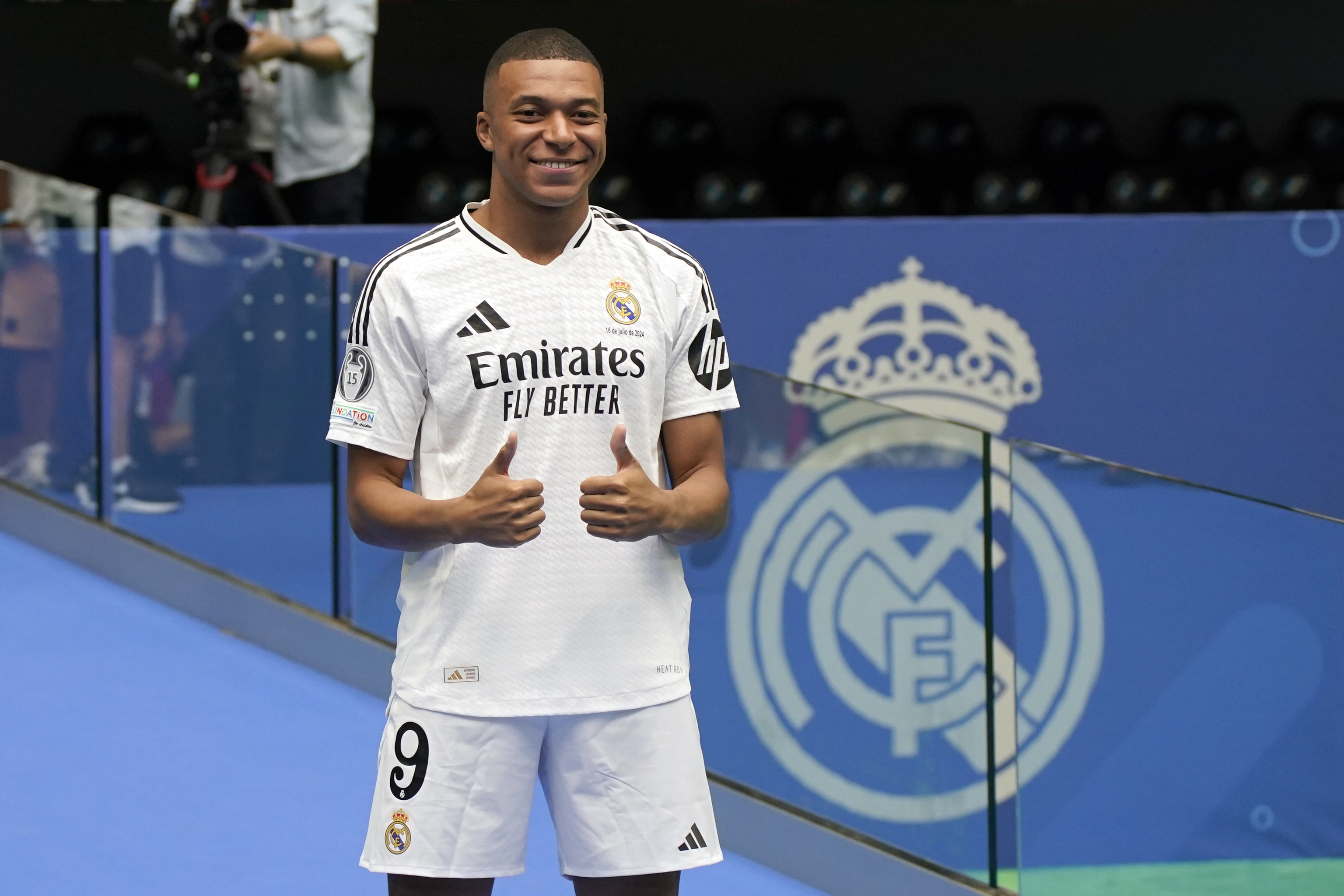 Kylian Mbappe poses for the cameras after being presented to fans as a new Real Madrid player.