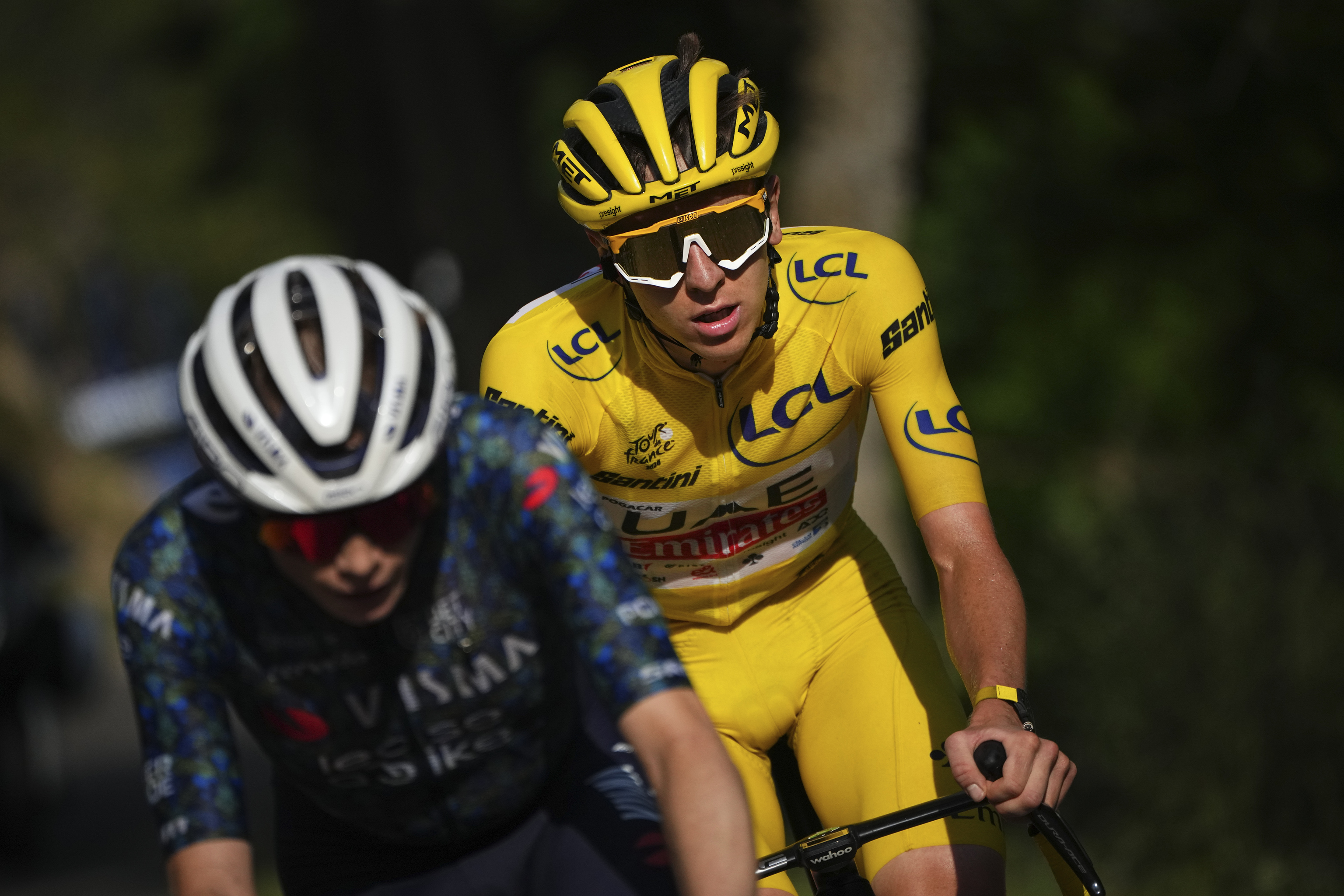 Slovenia's Tadej Pogacar, wearing the overall leader's yellow jersey, follows Denmark's Jonas Vingegaard during the twentieth stage of the Tour de France.