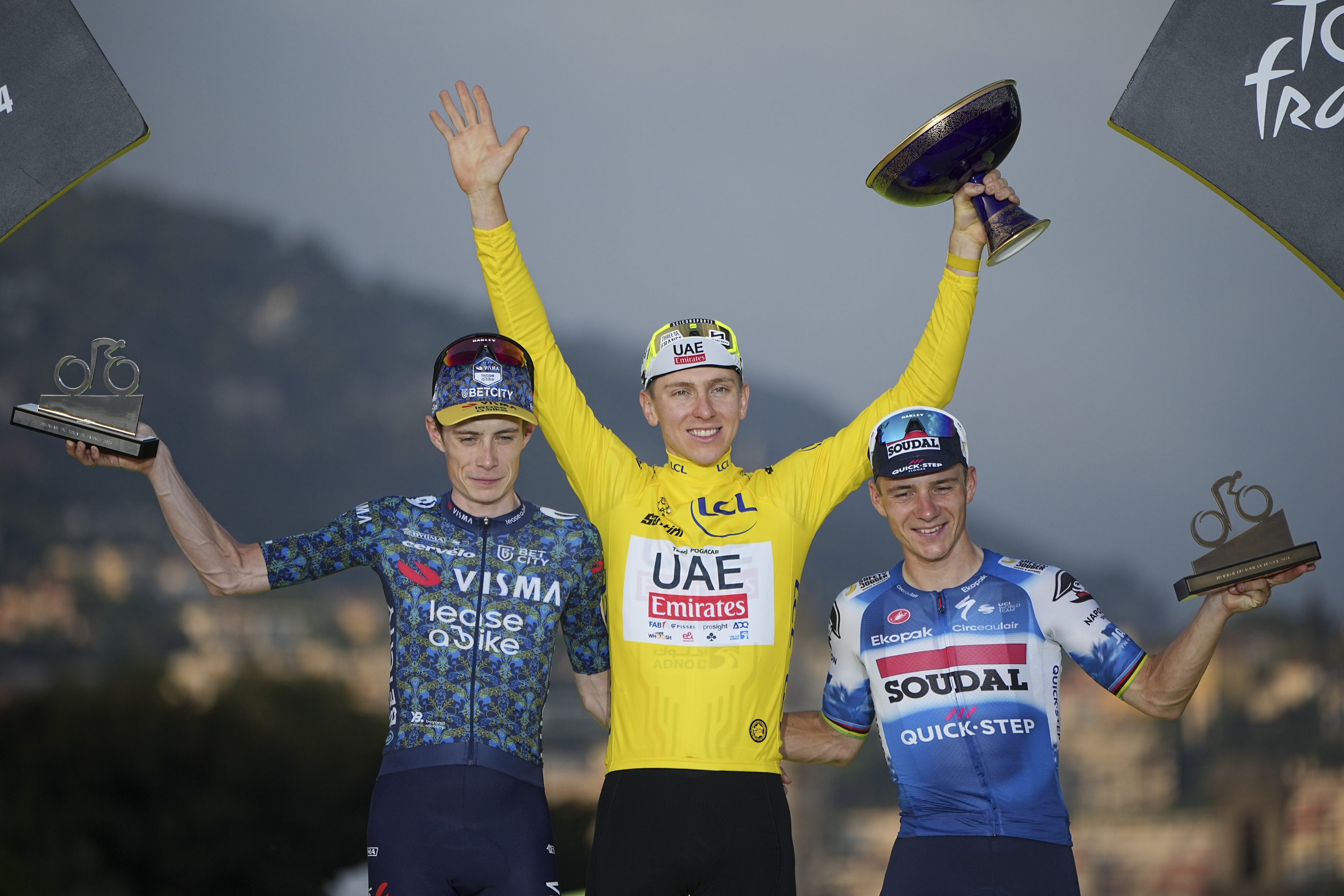 Tour de France winner Slovenia's Tadej Pogacar, wearing the overall leader's yellow jersey, Denmark's Jonas Vingegaard, left, and second place, and Belgium's Remco Evenepoel.