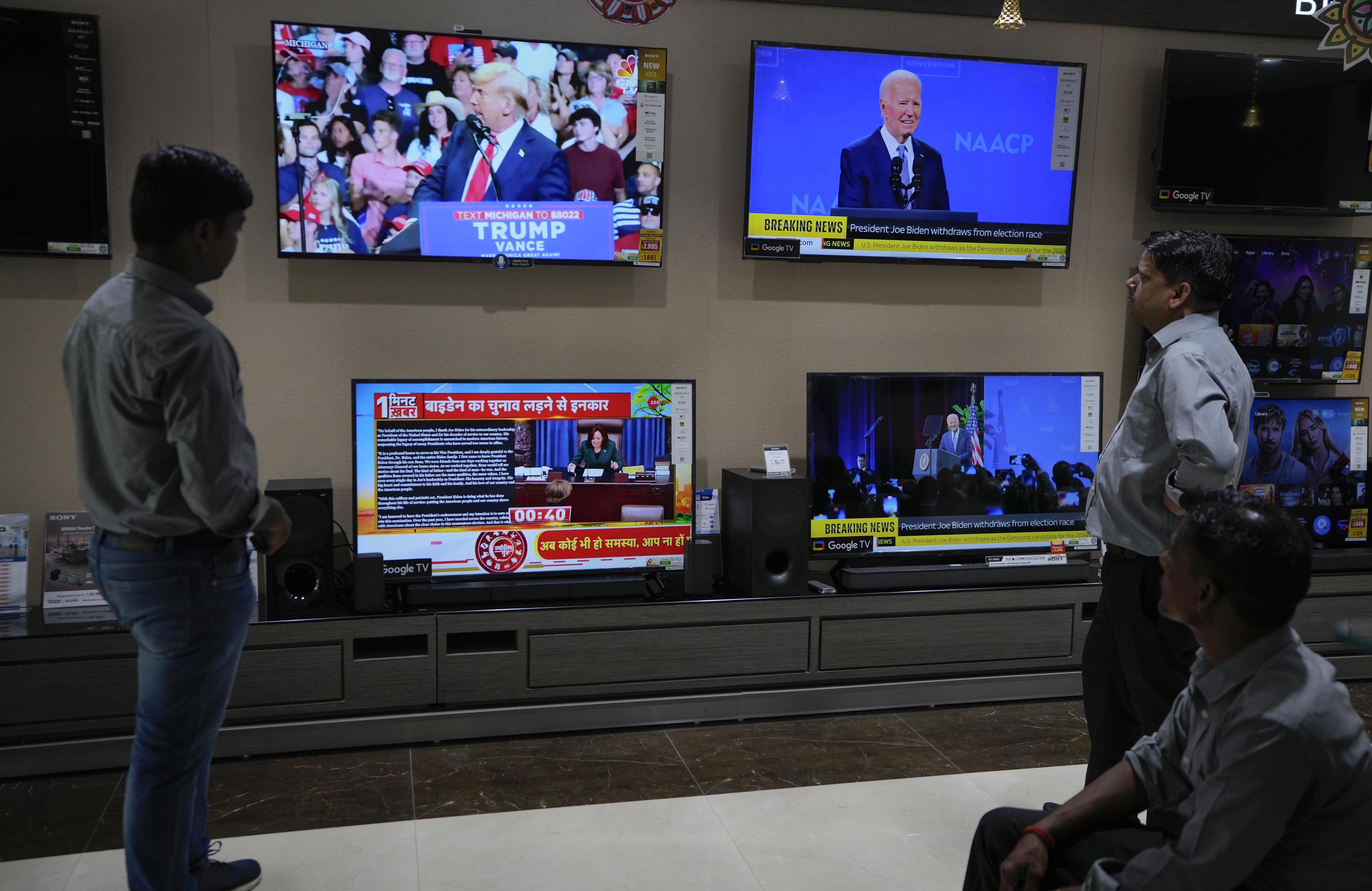 People watch the news of President Biden dropping out.