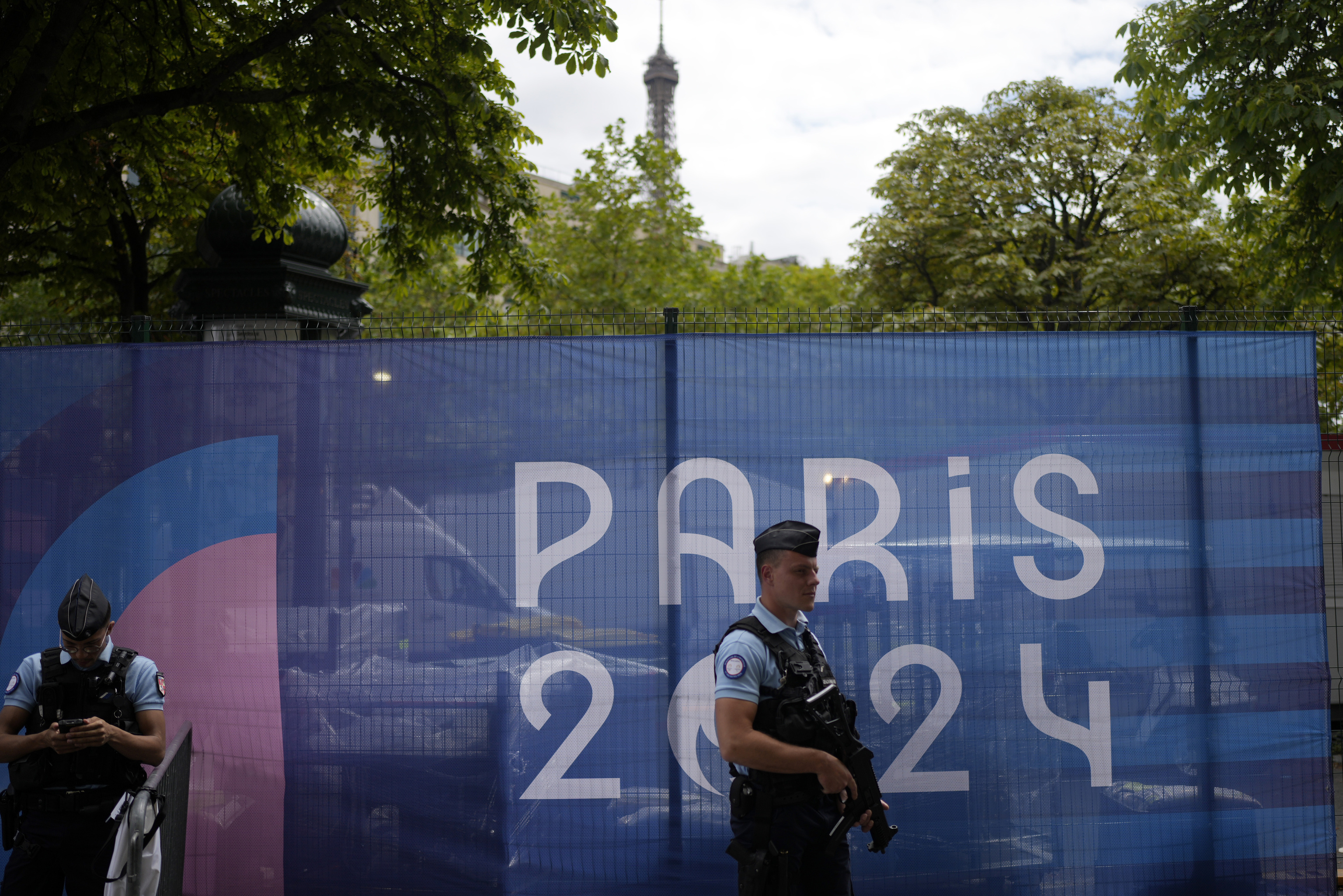 Police officers patrol near the Eiffel Tower.