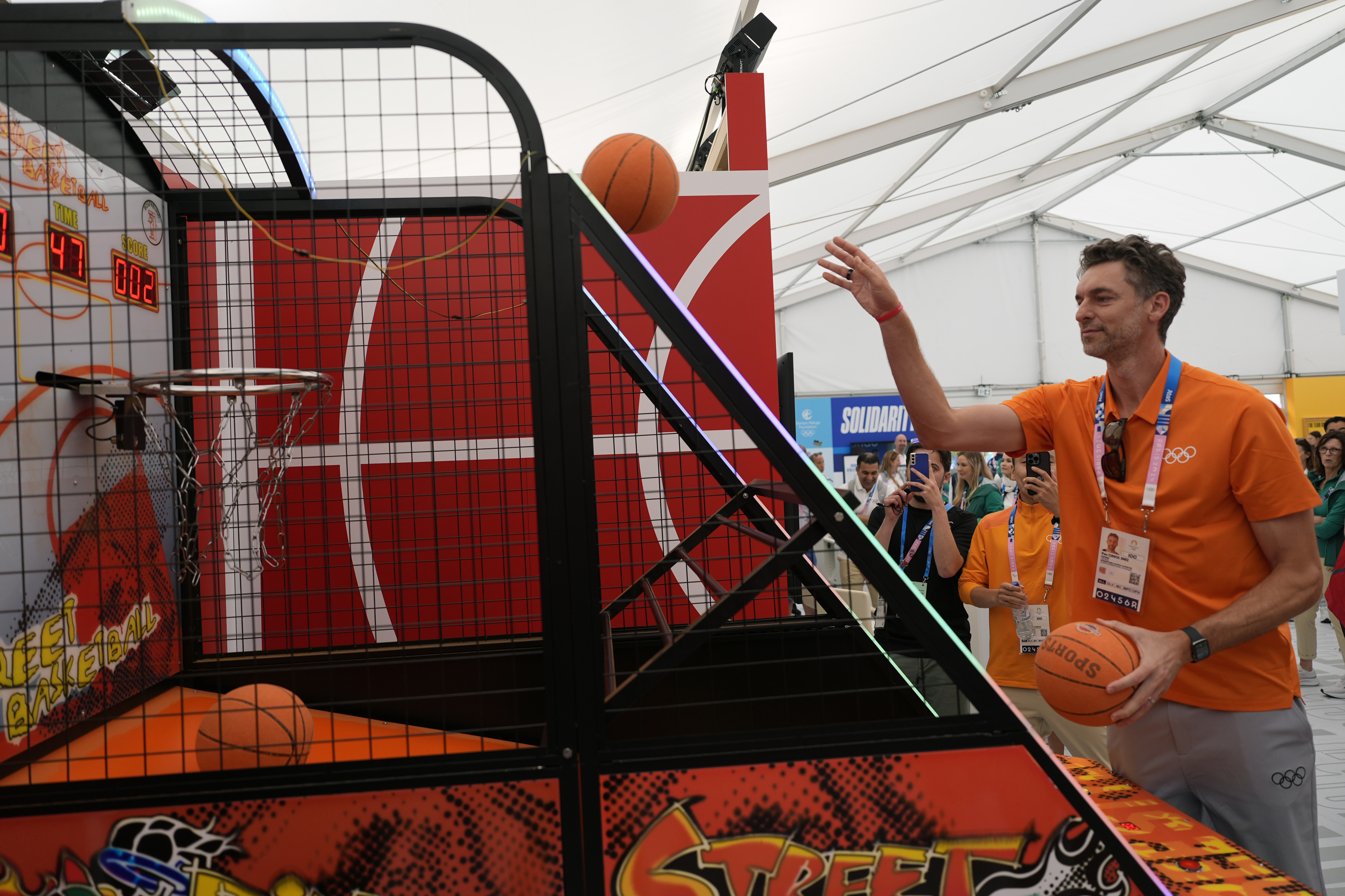 Pau Gasol plays basketball during a visit to the Olympic village.