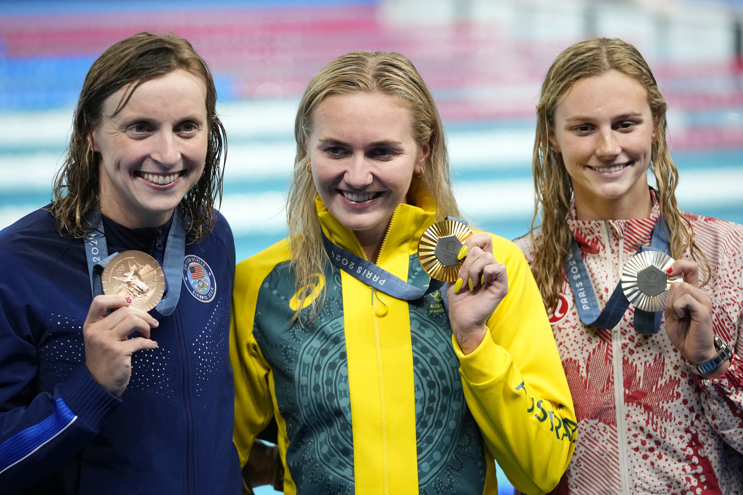 Gold medalist Ariarne Titmus, of Australia, middle, stands with silver medalist Summer McIntosh, of Canada, right, and bronze medalist Katie Ledecky, of the United States.