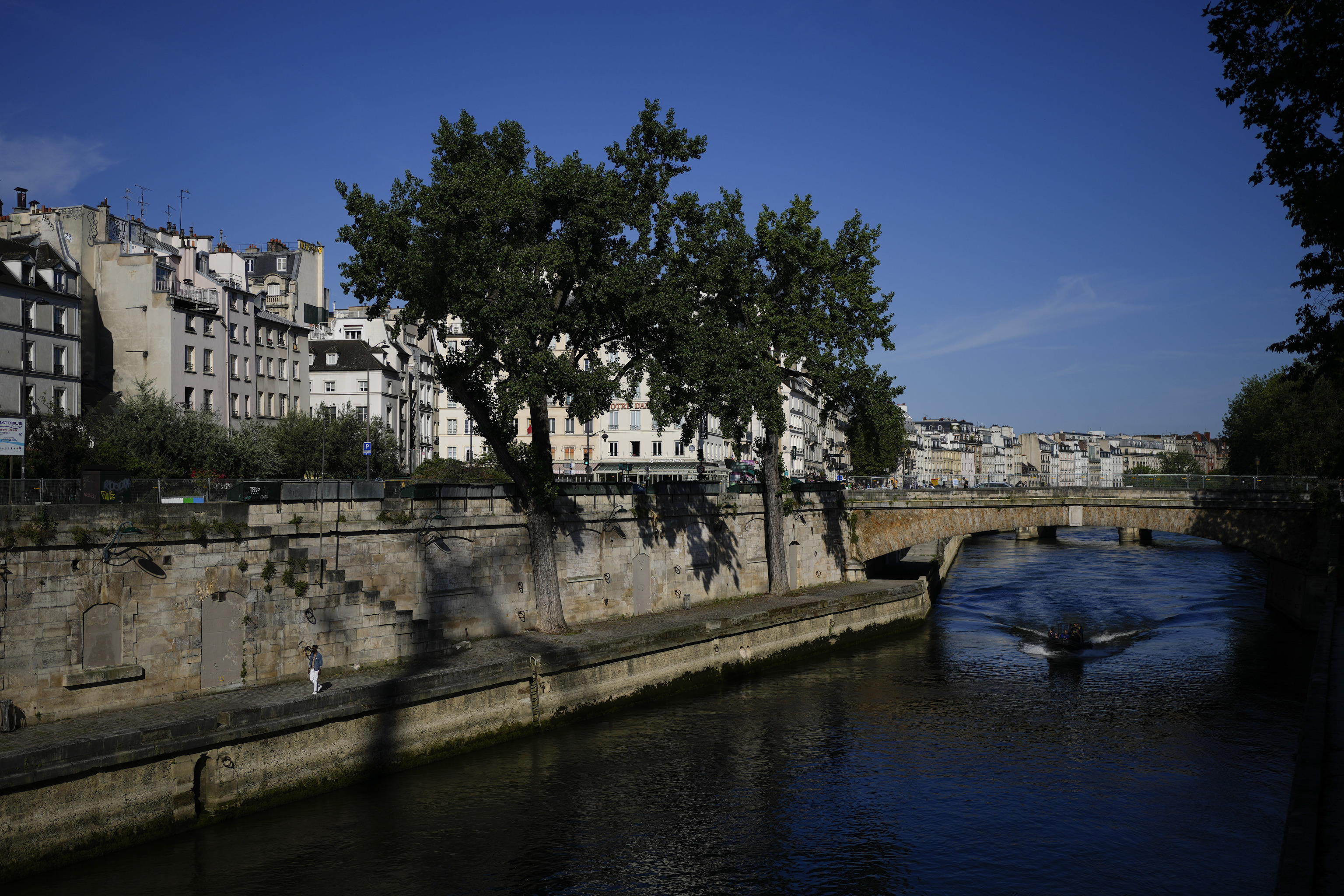 A man walks along the Seine river.