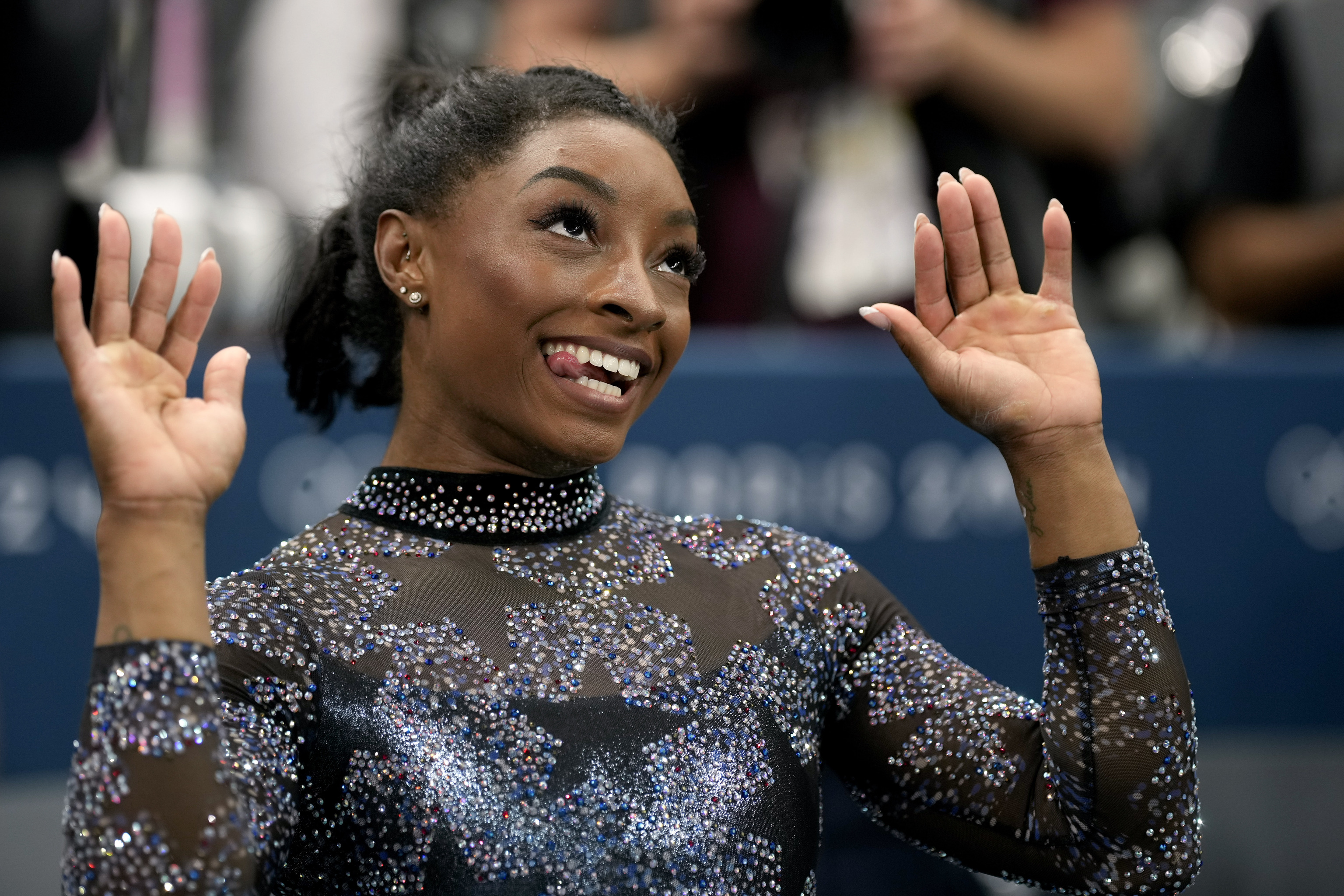 Simone Biles, of United States, celebrates after competing on the uneven bars.