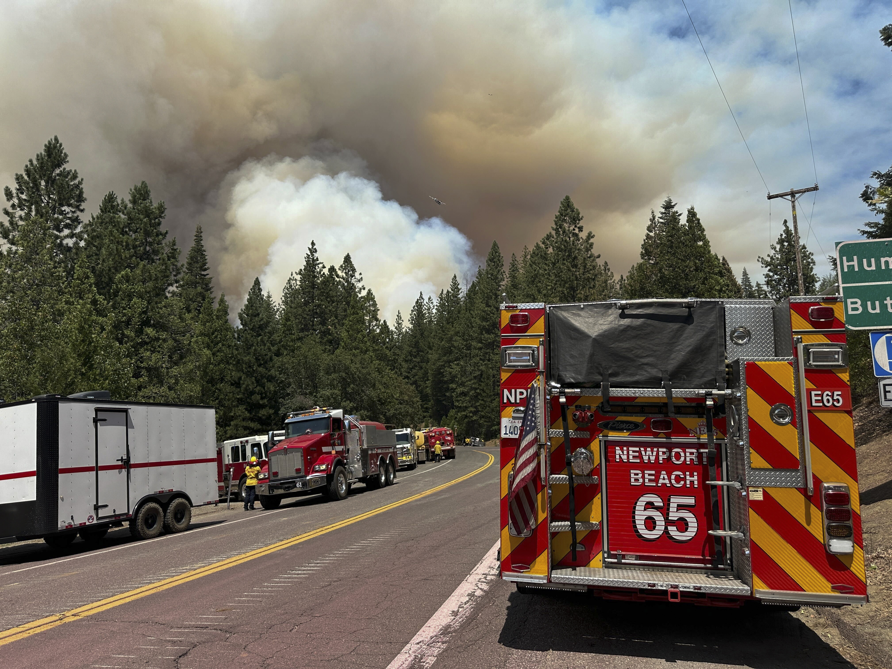 Smoke from the Park Fire rises over emergency vehicles.