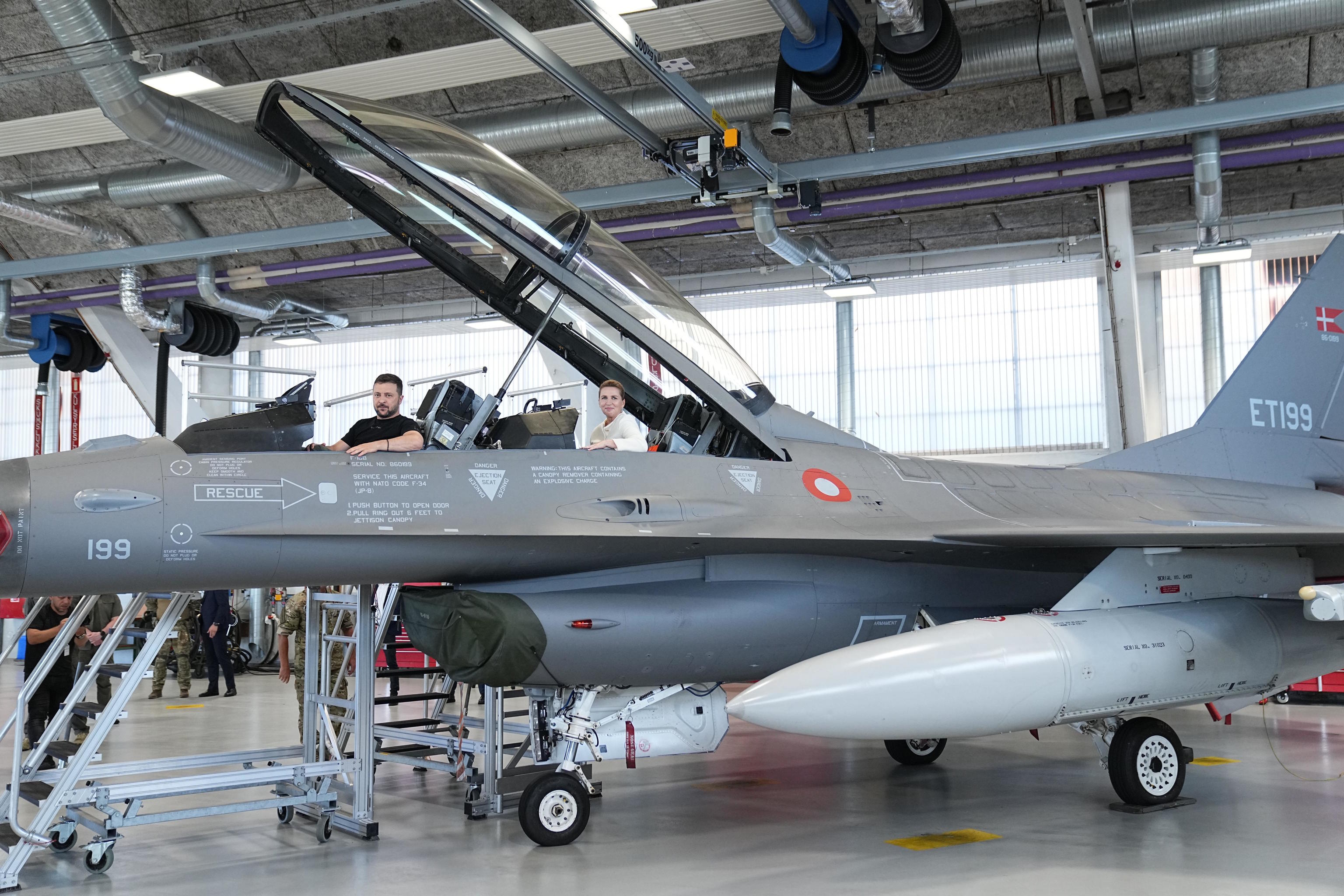 Zelenskyy and Denmark's Prime Minister sit in a F-16.