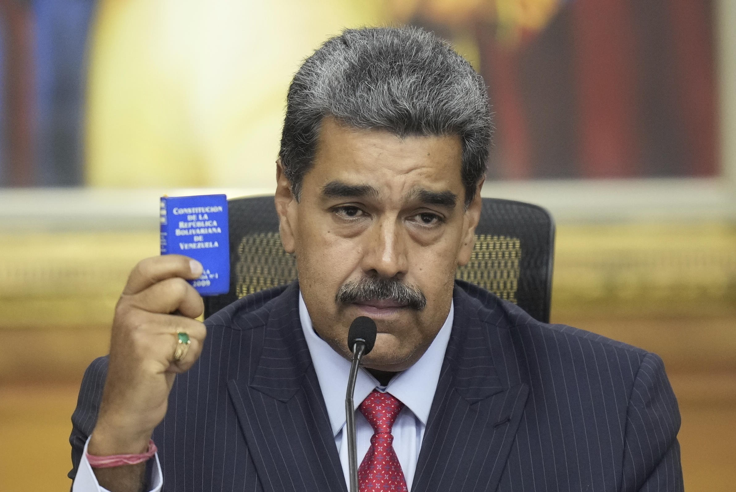 Maduro holds a small copy of the constitution.