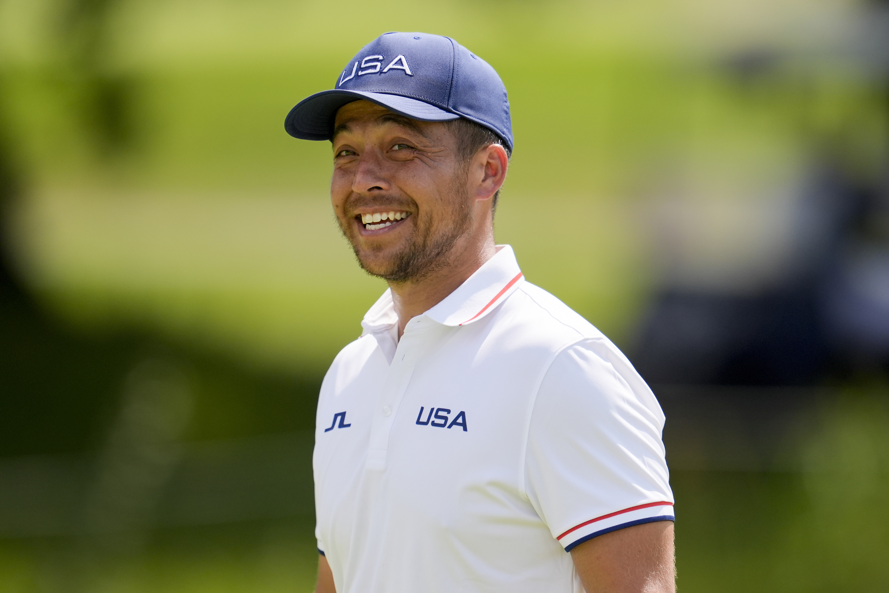 Xander Schauffele, of the United States, smiles on the 13th green during a practice round.