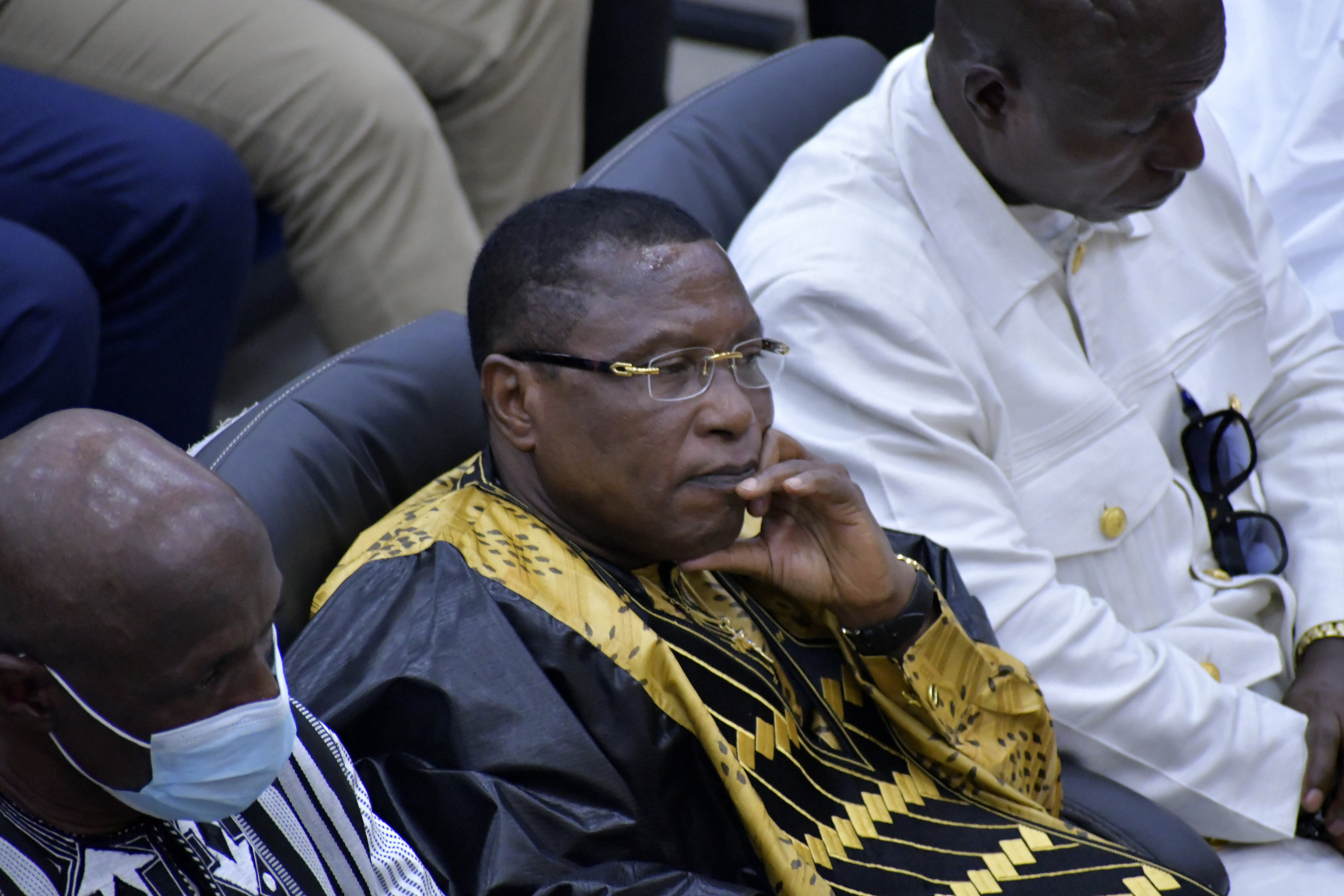 Former junta leader Moussa "Dadis" Camara, left, listens during a court verdict in Conakry.