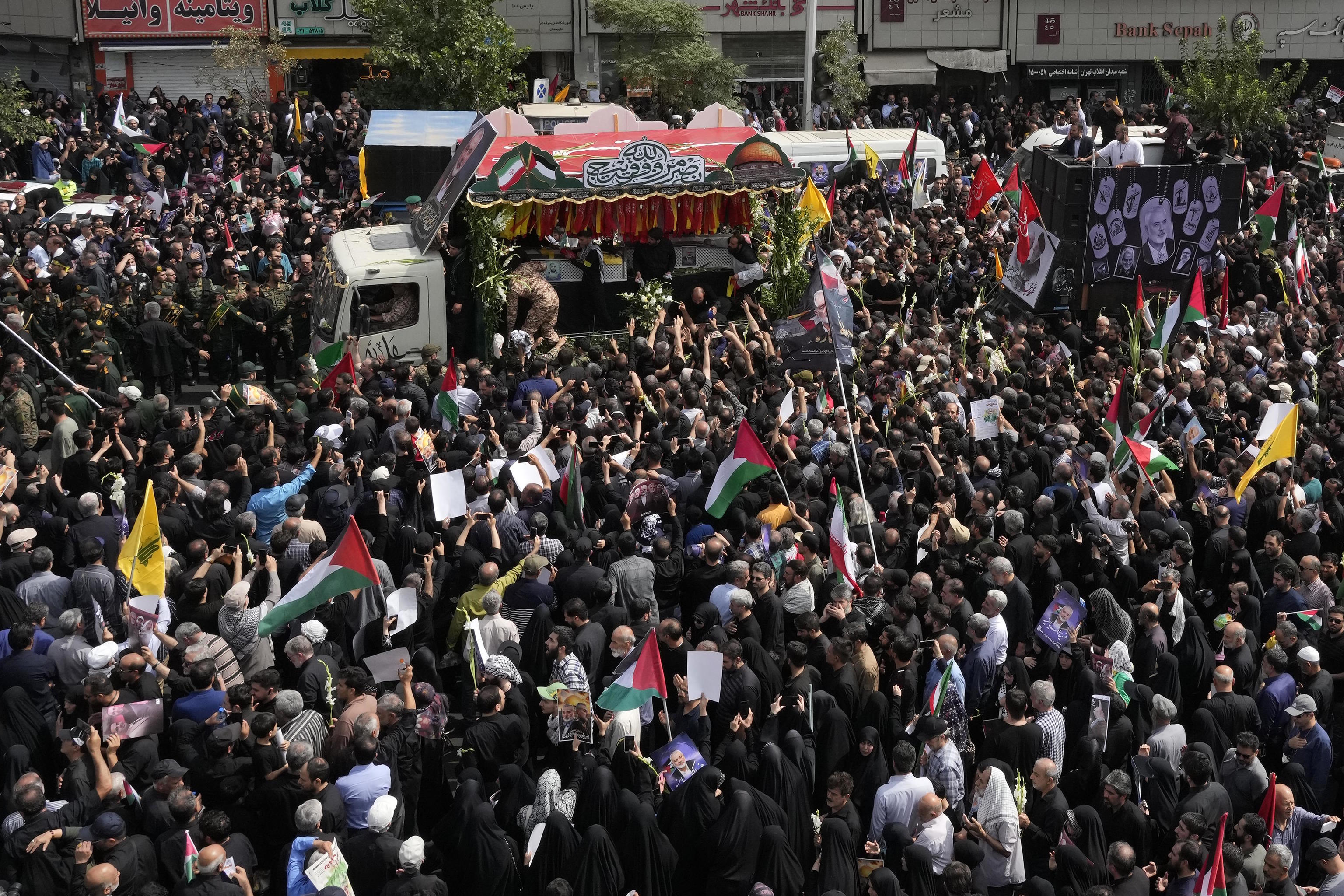 Iranians follow the truck carrying the coffin of Haniyeh.