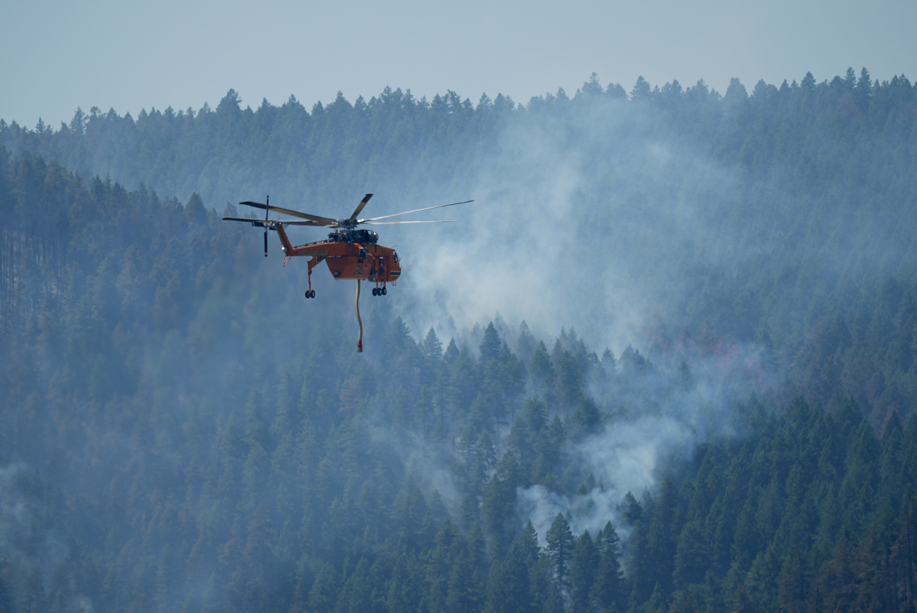 A helicopter looks to make a water drop.