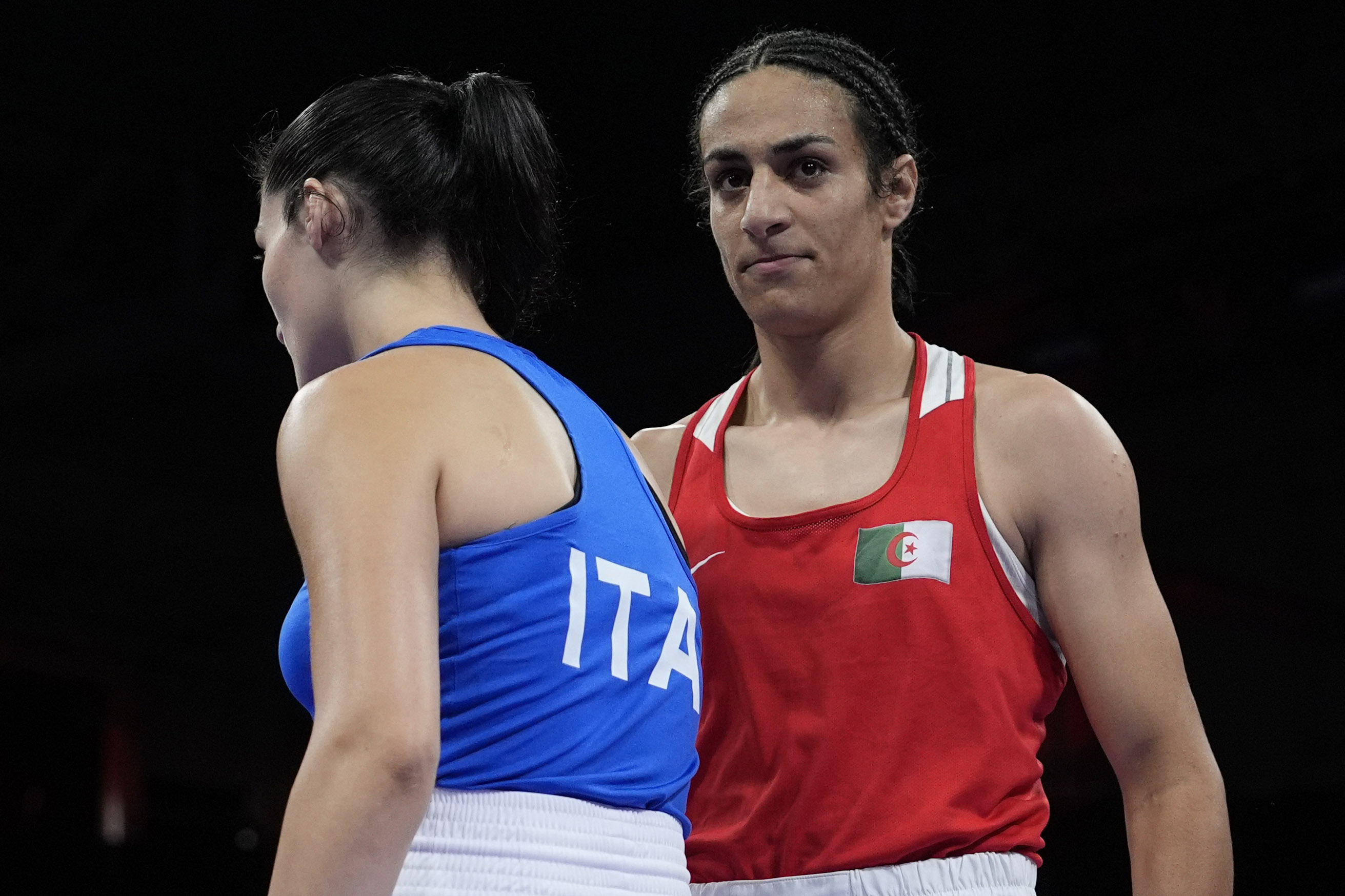 Algeria's Imane Khelif, right, walks beside Italy's Angela Carini.